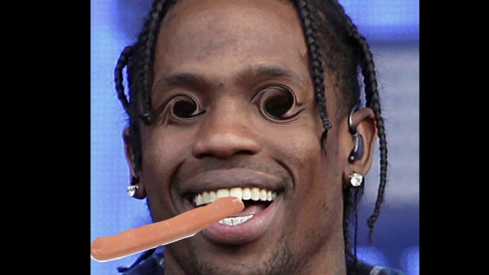Travis Scott Funny 桌布 壁紙 — 一名梳著辮子頭髮、戴著鑽石耳環的男子，在藍色背景前微笑著將熱狗叼在嘴裡。