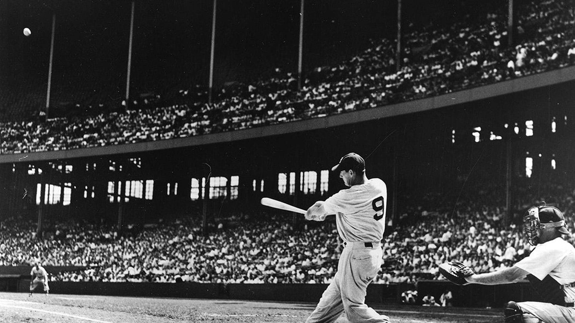 Joe Dimaggio 桌布 壁紙 — 一名棒球手在球場燈光下揮棒擊球，滿座觀眾以黑白畫面觀看。