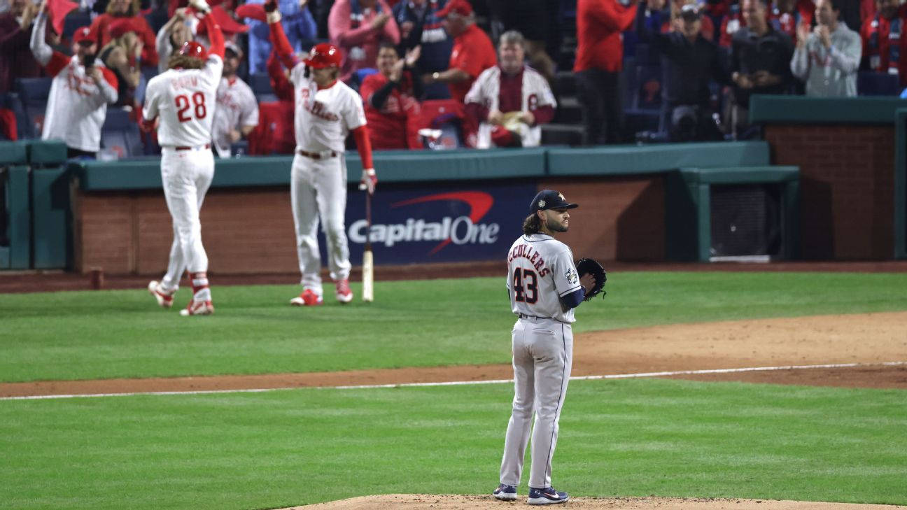 Houston Astros 桌布 壁紙 — 一名棒球投手獨自站在投手丘上，隊友在背景中於球場燈光下慶祝。