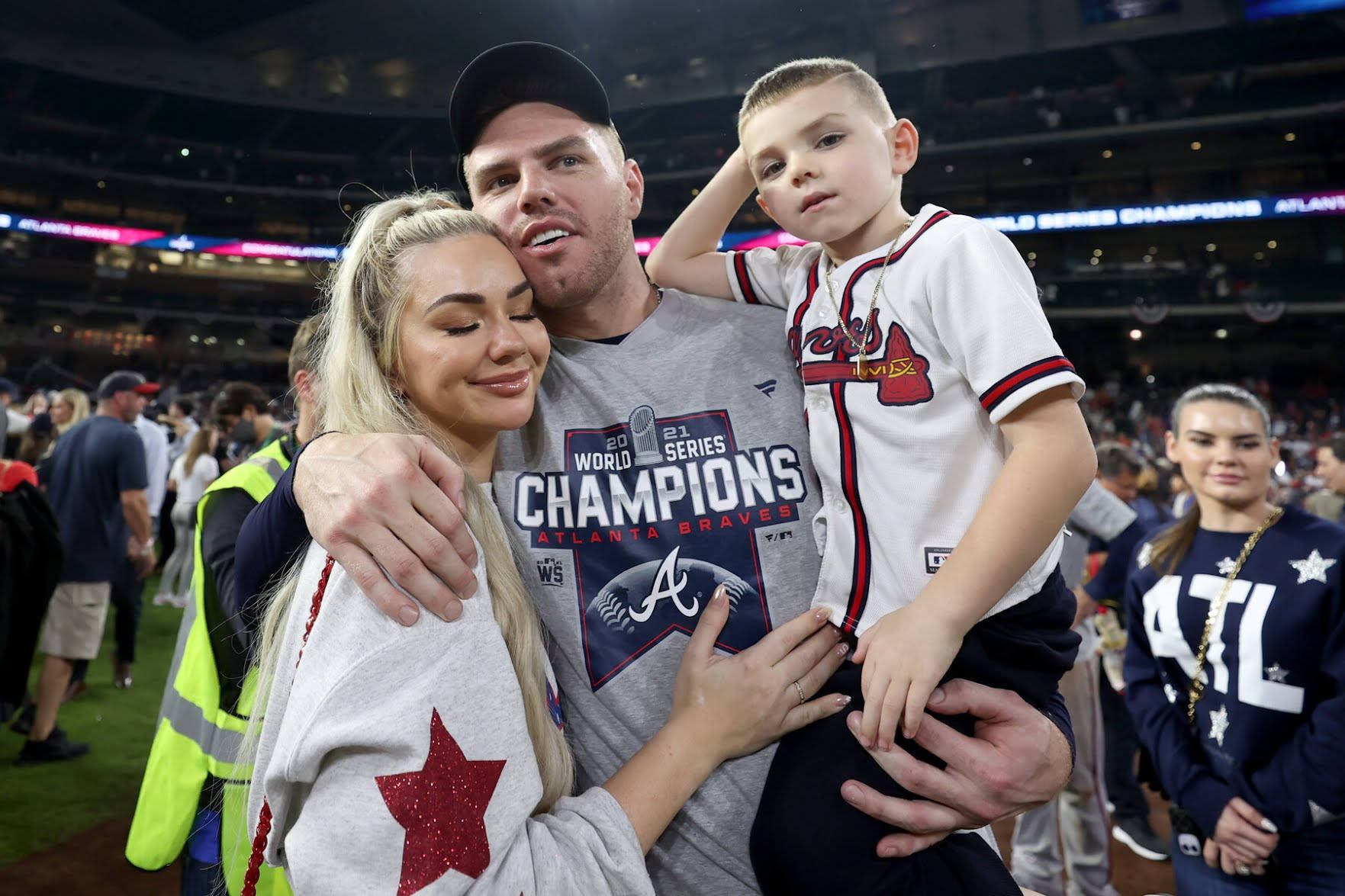 Freddie Freeman 桌布 壁紙 — 一名棒球選手在贏得2021年世界大賽冠軍後，在球場上擁抱家人。