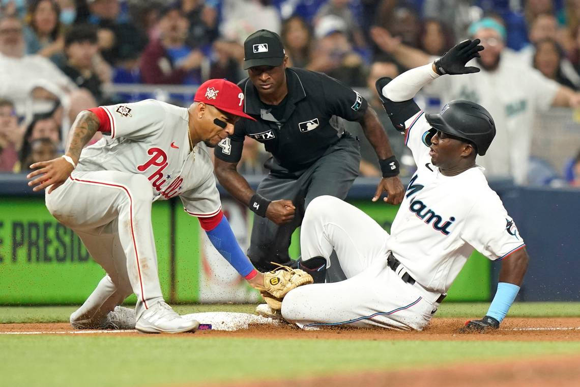 Phillies 桌布 壁紙 — 一名棒球選手滑進本壘，而對方球員和裁判在一場緊張的比賽中專注地觀看。