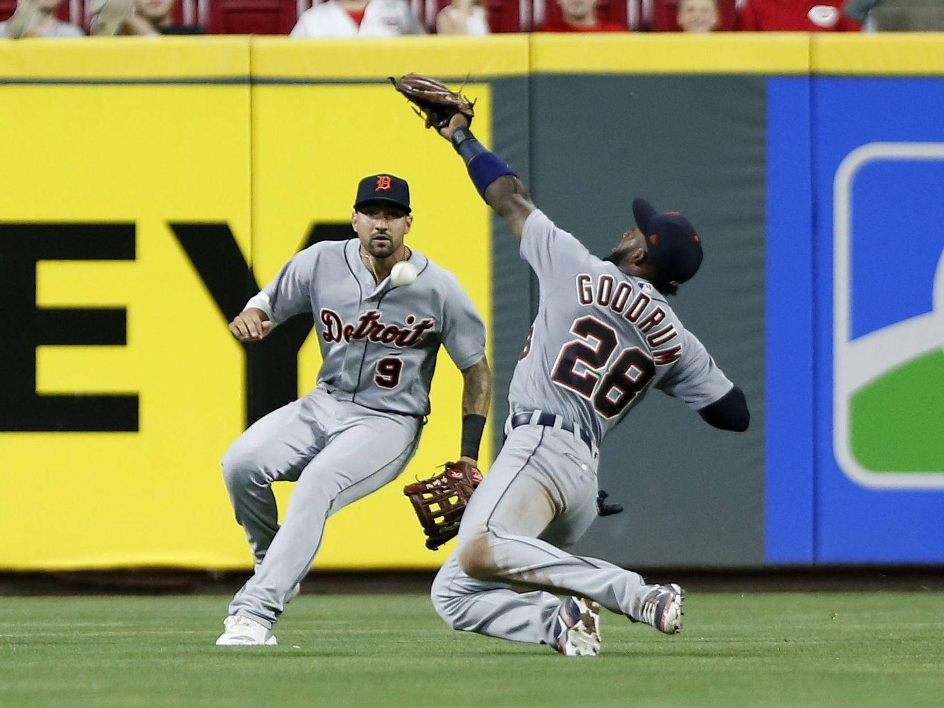 Nick Castellanos 桌布 壁紙 — 一名棒球選手飛身接球，另一名選手在明亮的綠色場地上專注觀看。