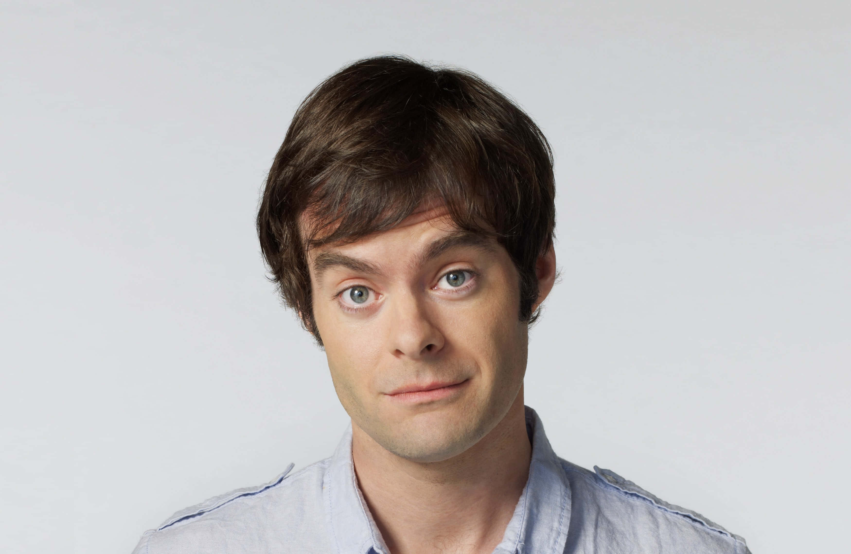 bill hader 桌布 壁紙 — 一名棕色頭髮、藍色眼睛的男子在純白背景下直視鏡頭，帶著一絲微笑。