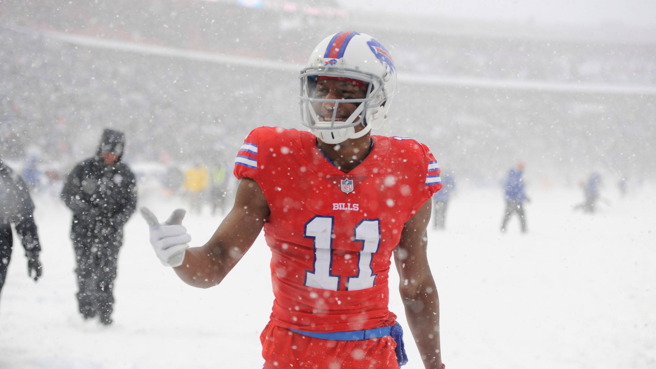 zay jones 桌布 壁紙 — 一名水牛城比爾隊的足球員身穿紅色11號球衣，在球場上大雪紛飛時豎起大拇指。