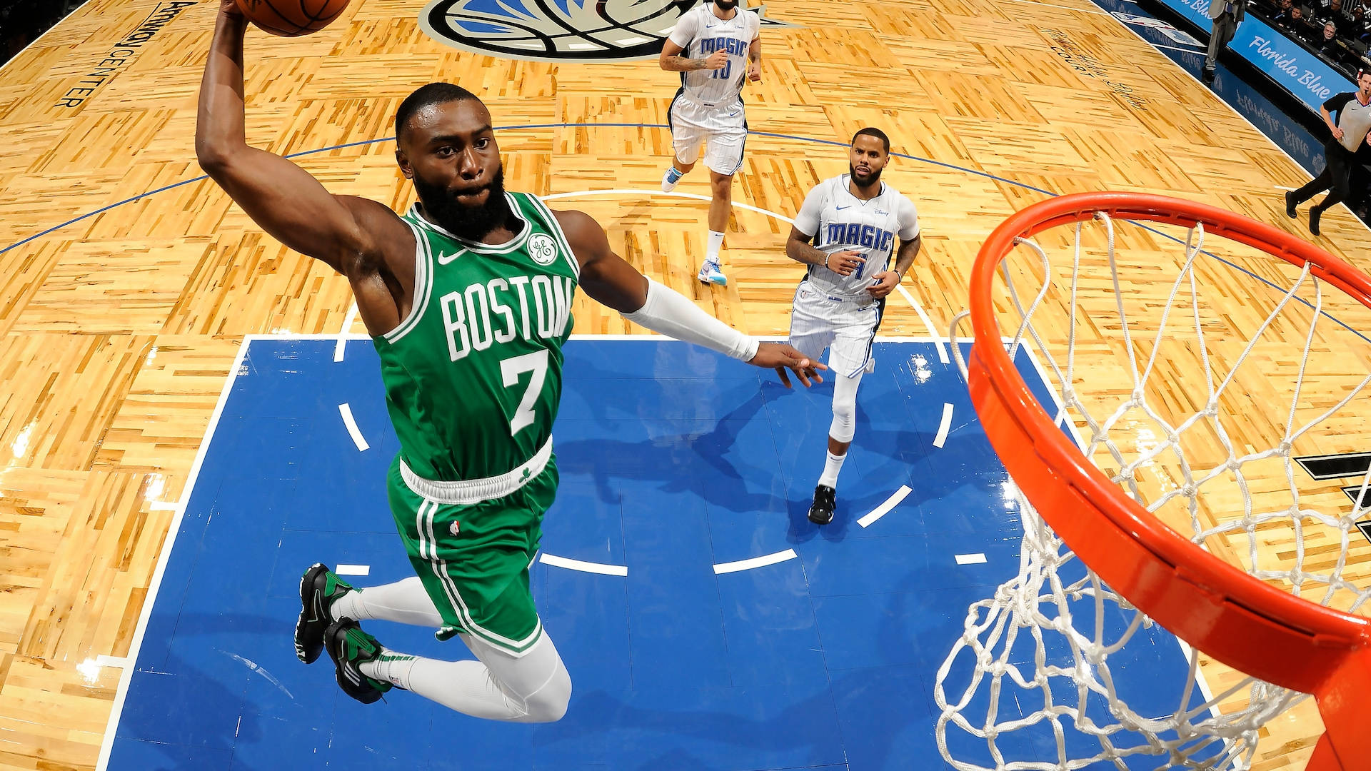 Jaylen Brown 桌布 壁紙 — 一名波士頓塞爾提克球員高高躍起灌籃，對手在拋光木地板上從下方觀看。