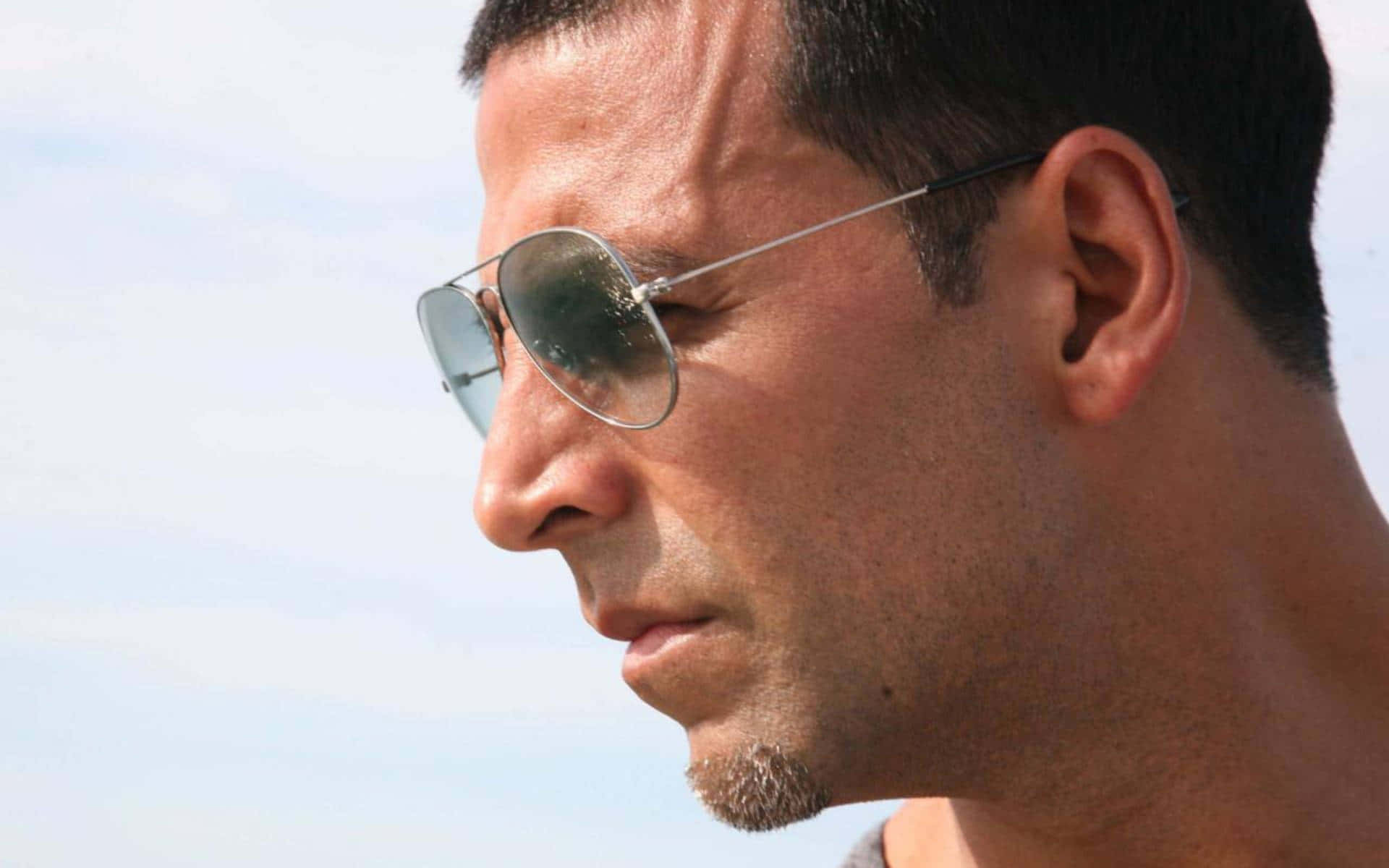 Akshay Kumar 桌布 壁紙 — 一名深色頭髮、戴著太陽眼鏡的男士，在明亮的天空下若有所思地凝視的 close-up 側面照。