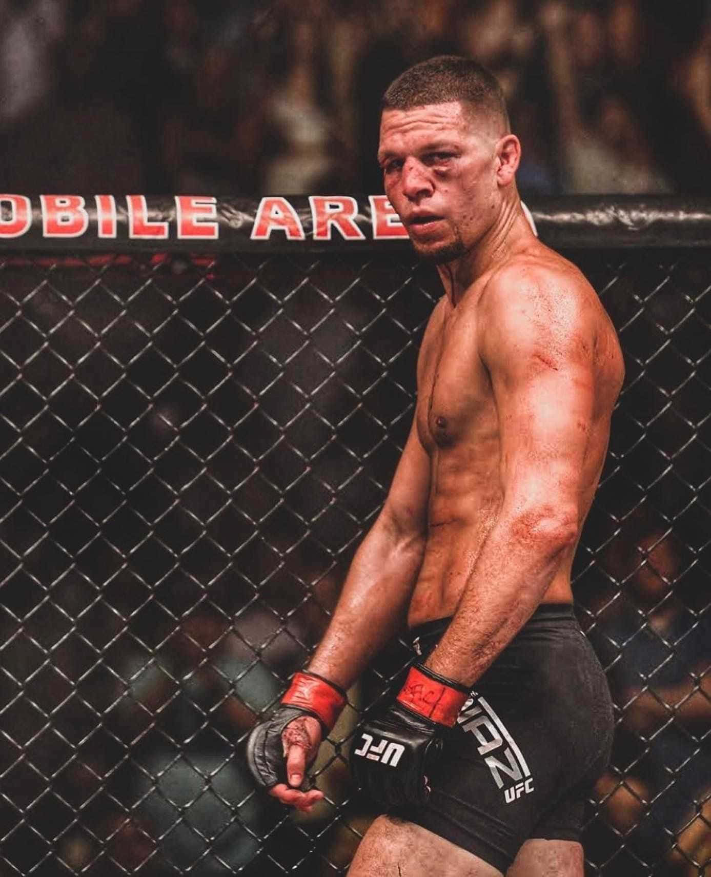 UFC 桌布 壁紙 — 一名渾身是血、筋疲力竭的綜合格鬥選手在殘酷的比賽後站在UFC八角籠內。