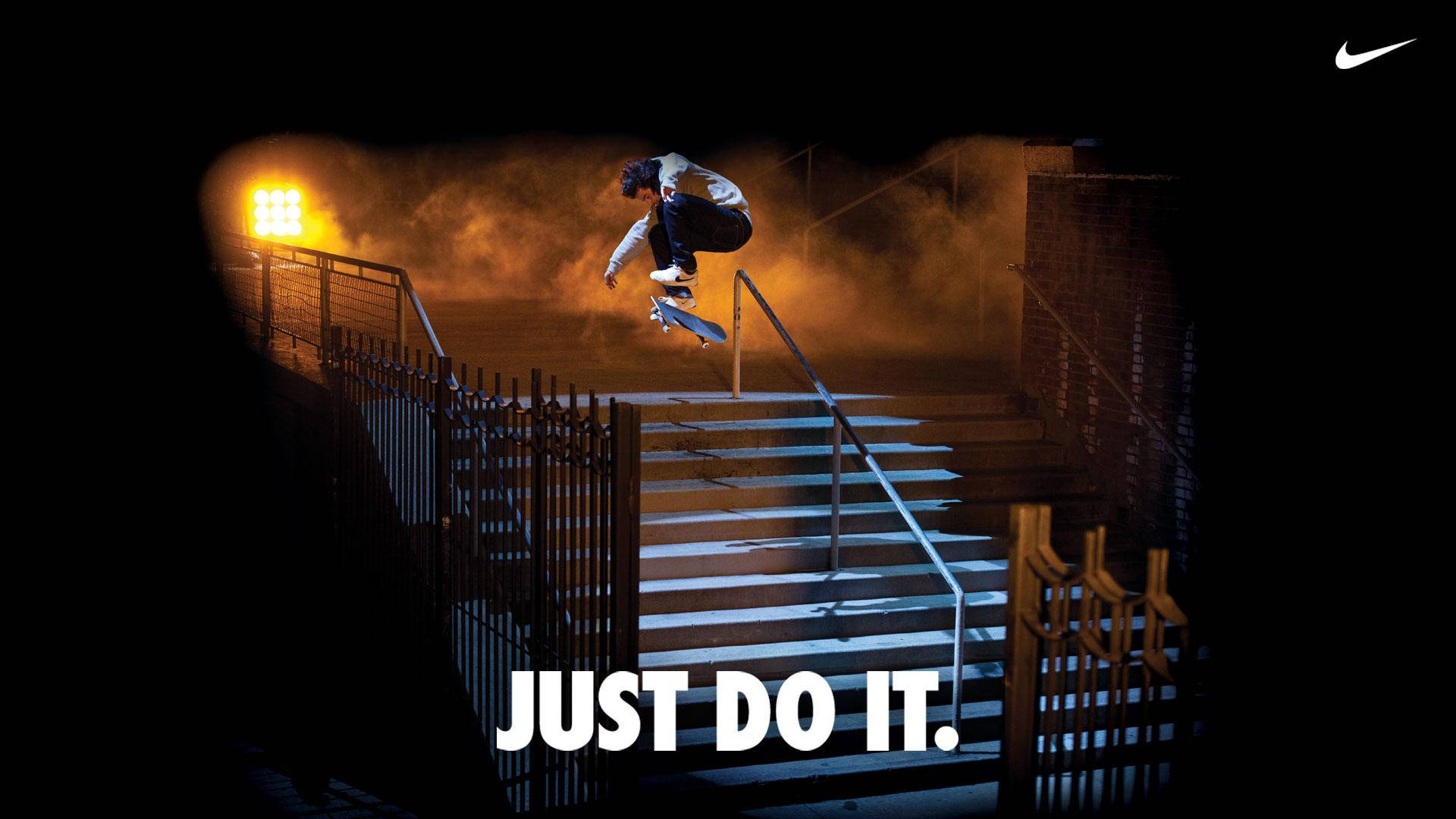 Just Do It 桌布 壁紙 — 一名滑板手在夜間溫暖的橙色舞台燈光下，於樓梯上方凌空表演技巧。