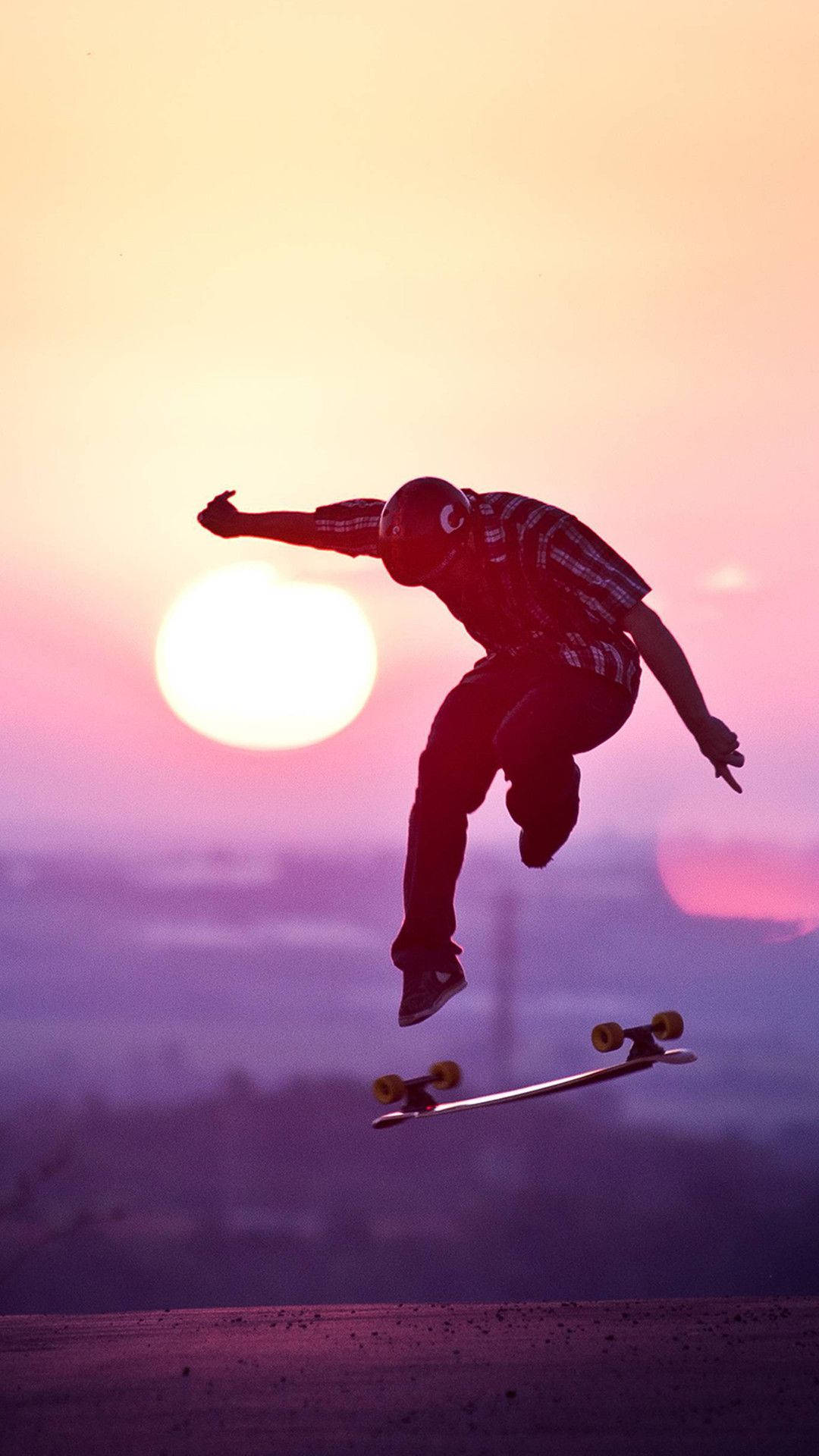 Silhouette 桌布 壁紙 — 一名滑板手在空中剪影，背景是發光的日落、明亮的太陽和紫色的天空。