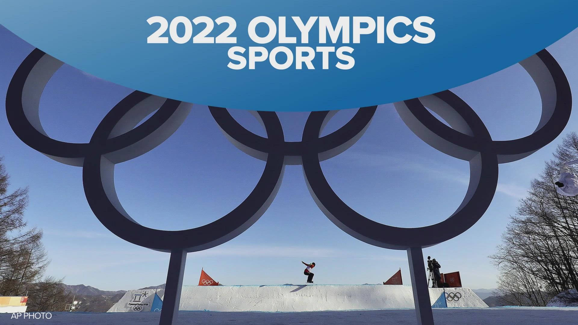 Winter Olympics 桌布 壁紙 — 一名滑雪板運動員在2022年冬奧的巨大奧運五環下翱翔，背景是晴朗的藍天。