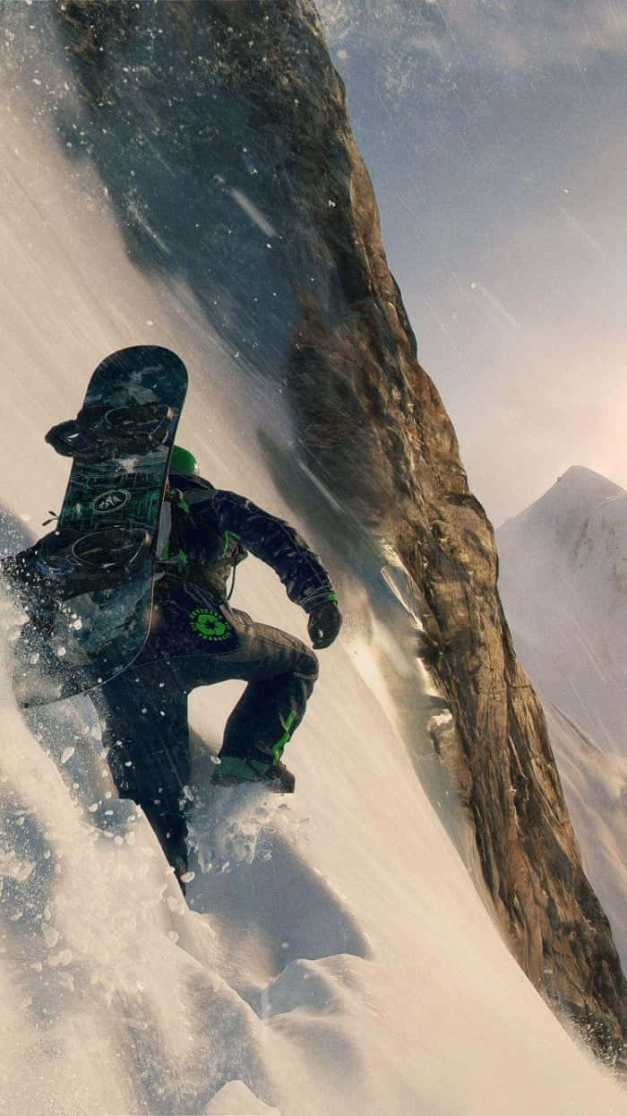 Steep 桌布 壁紙 — 一名滑雪板運動員在岩石懸崖旁邊的陡峭雪山斜坡上刻滑而下。