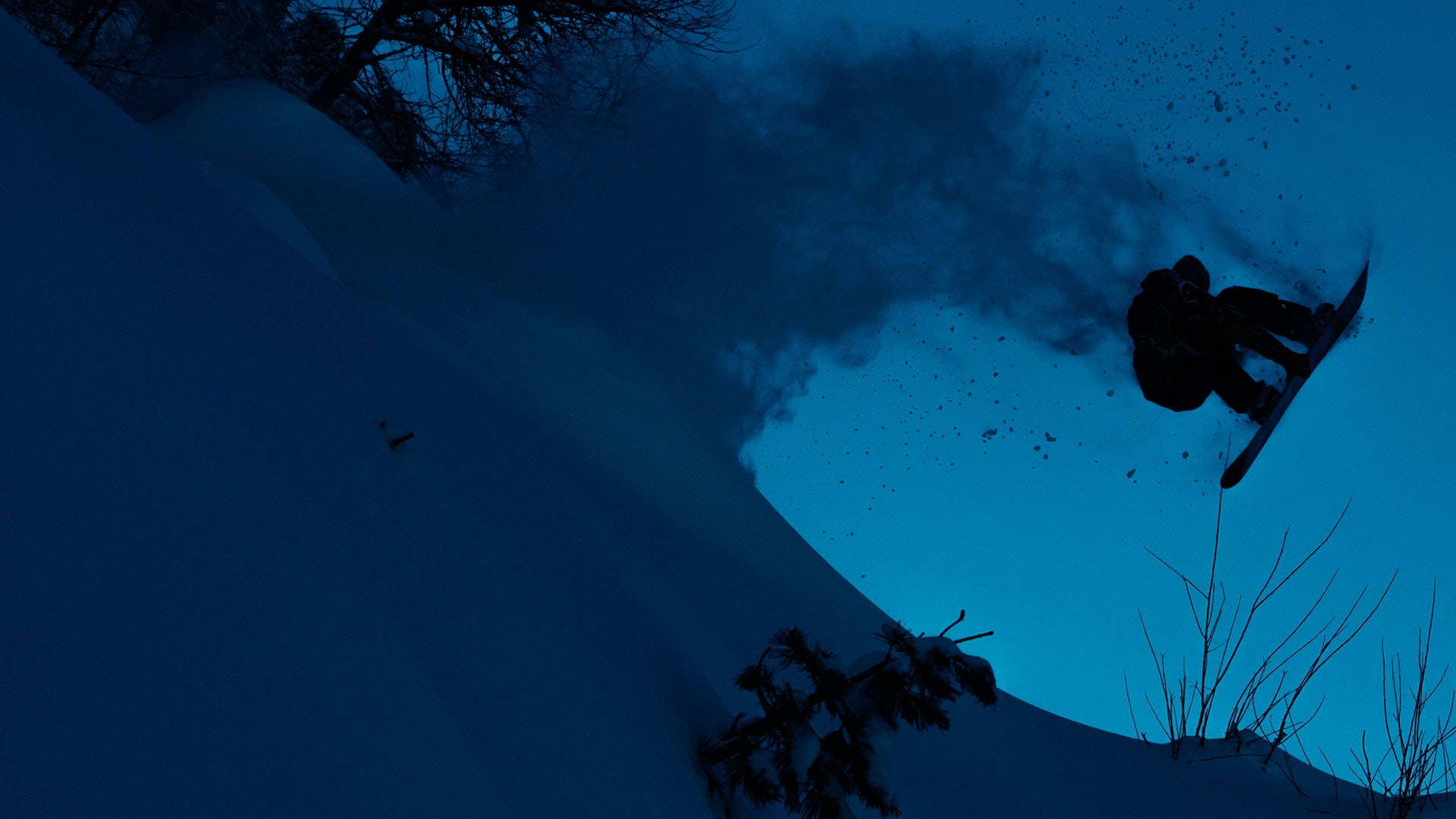 Snowboarding 桌布 壁紙 — 一名滑雪板運動員在深藍色暮色天空的襯托下，從雪坡上躍起，形成剪影。