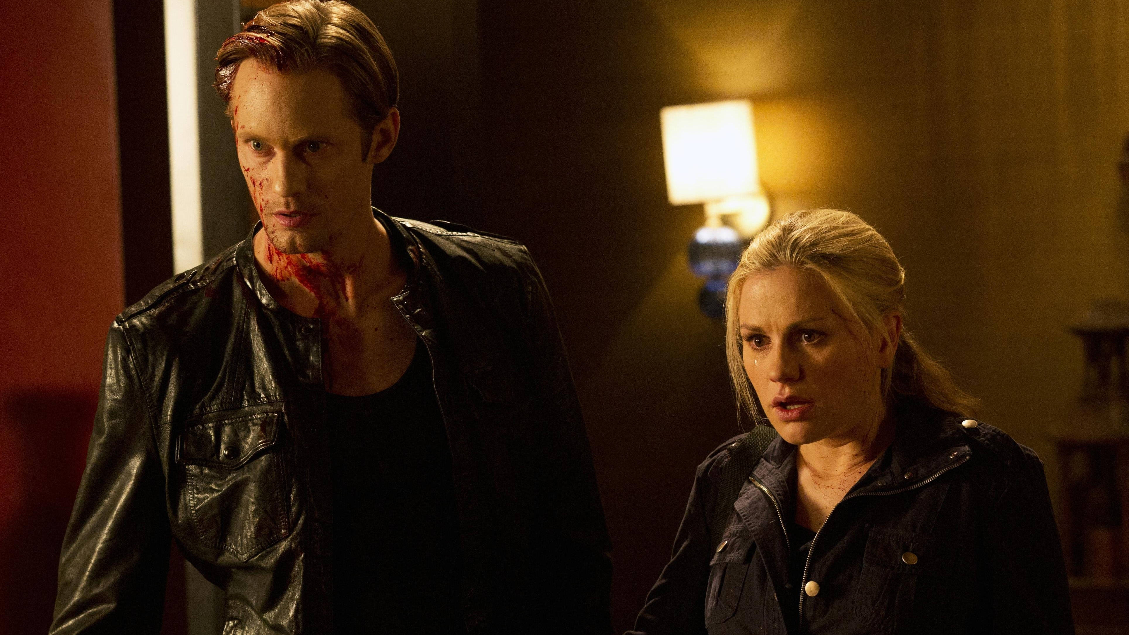 True Blood 桌布 壁紙 — 一名滿臉和頸部沾滿血的男人站在一個光線昏暗、帶有溫暖環境照明的房間裡，旁邊有一個女人。