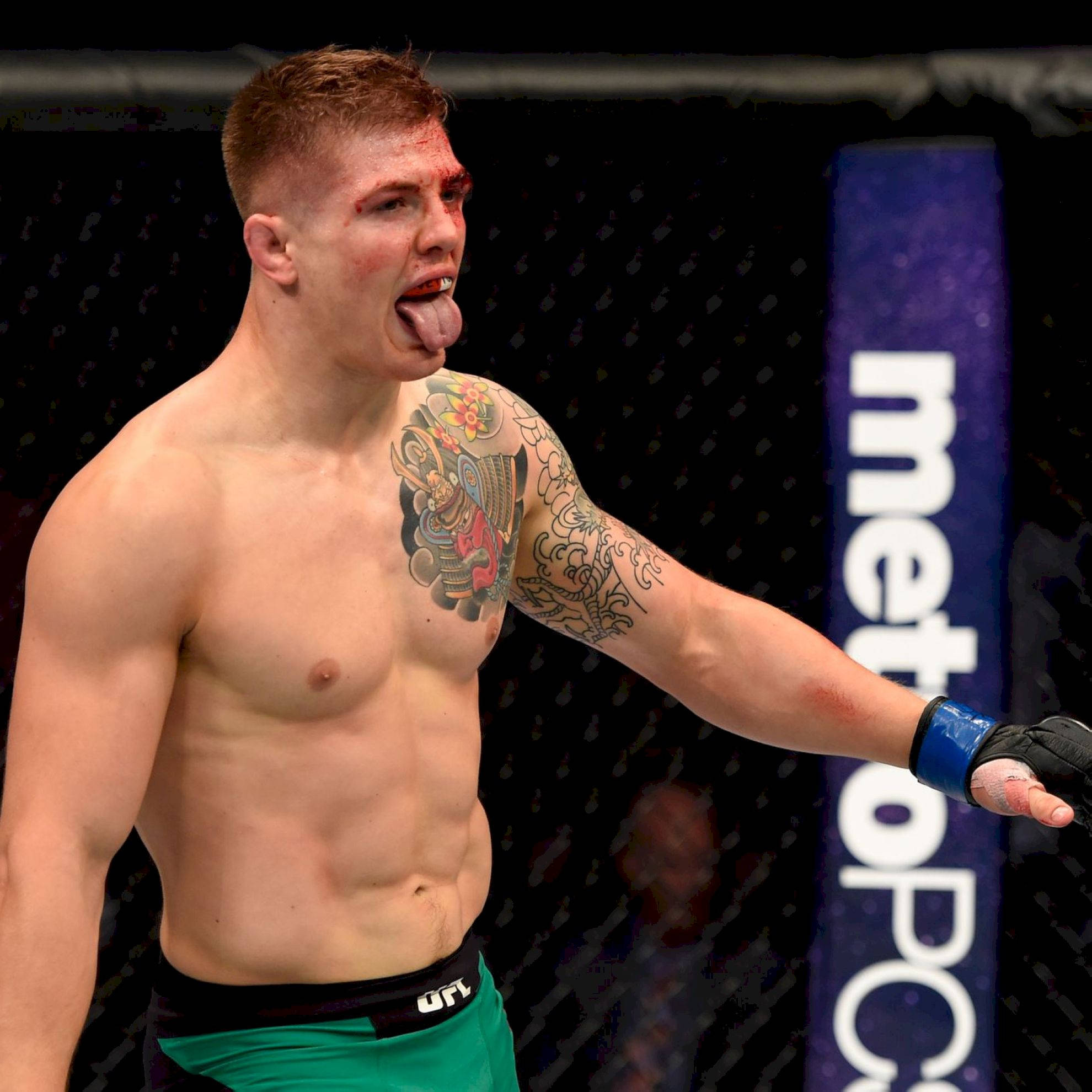 MMA 桌布 壁紙 — 一名滿身刺青、血跡斑斑的MMA拳手在八角籠賽後伸出舌頭。