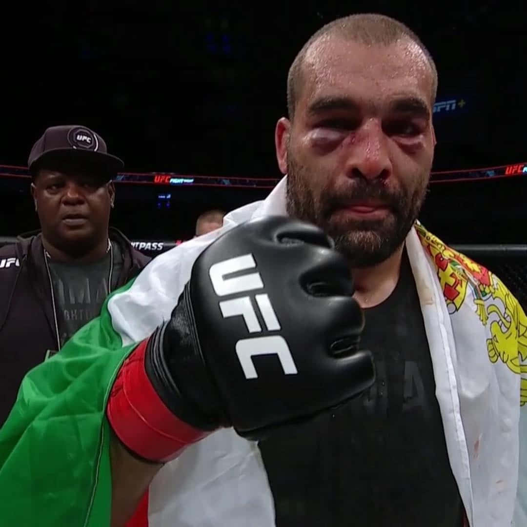 MMA 桌布 壁紙 — 一名滿身鮮血的UFC拳手，戴著黑色手套，肩上披著義大利國旗，在比賽後凝視著鏡頭。