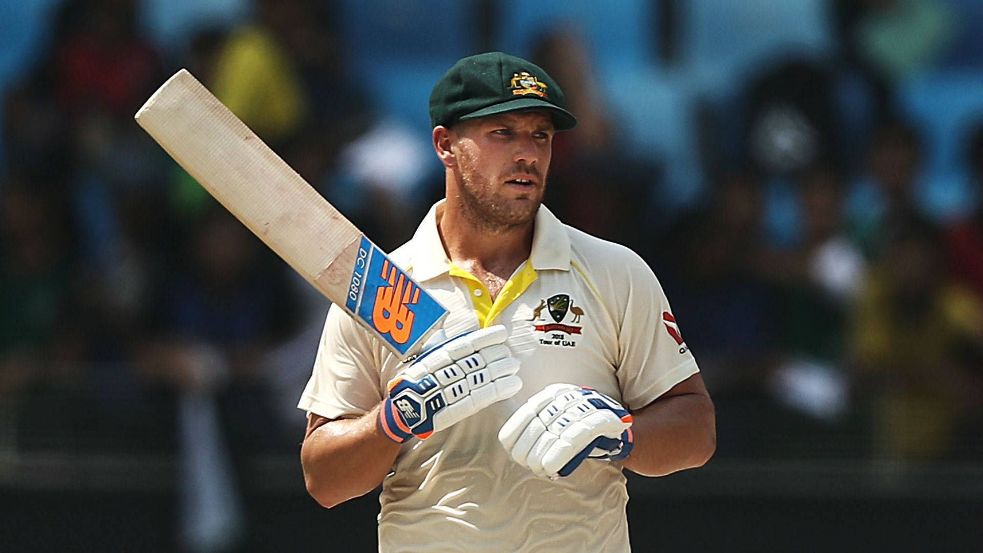 Aaron Finch 桌布 壁紙 — 一名澳洲板球運動員身穿制服，在日間比賽中專注地握著球棒。