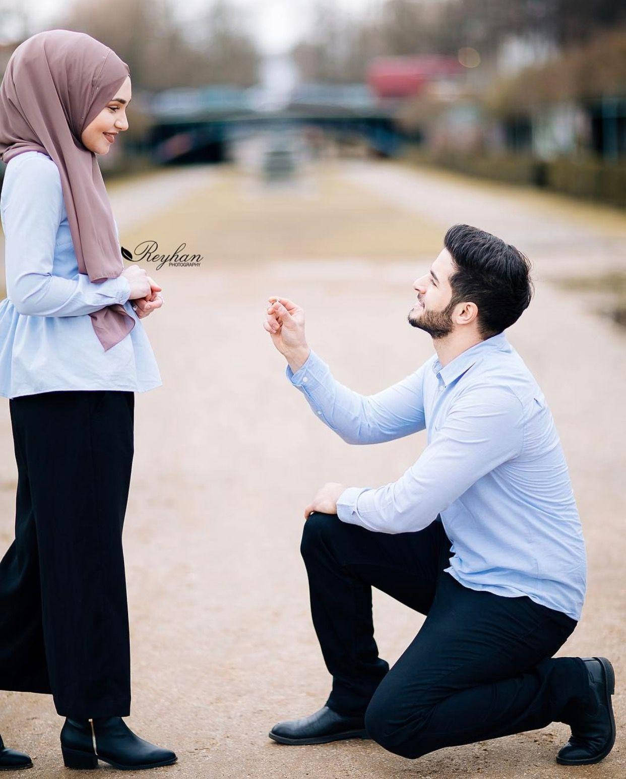 muslim 桌布 壁紙 — 一名男士單膝跪地，在柔和日光下，向一名戴著頭巾微笑的女士在運河旁求婚。