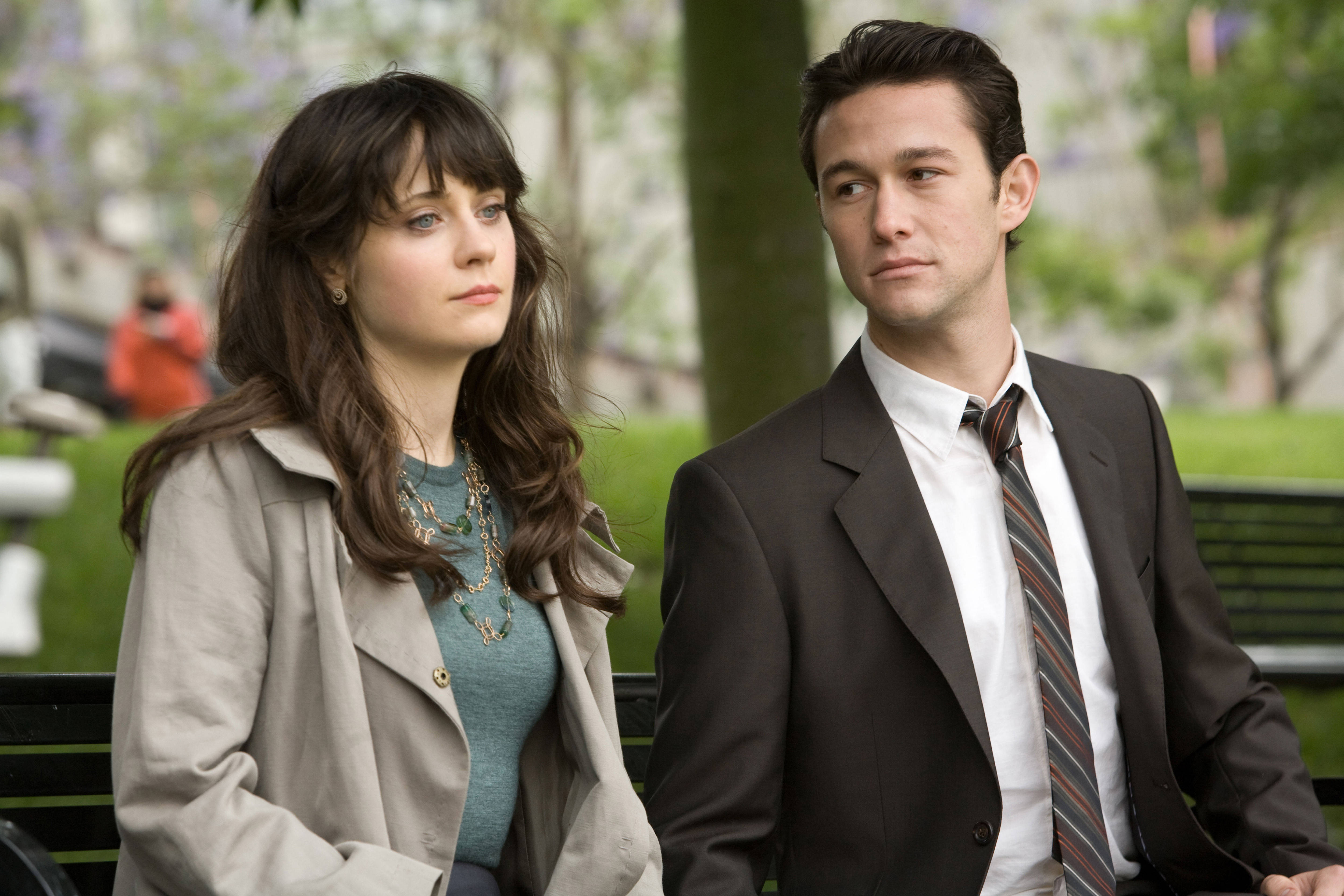 500 Days Of Summer 桌布 壁紙 — 一名男子和一名女子並排坐在公園長椅上，表情嚴肅，周圍環繞著綠植和柔和自然光。