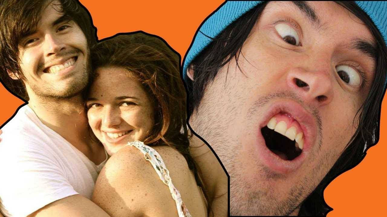 Couple Hug 桌布 壁紙 — 一名男子和一名女子溫暖地微笑，而第三名戴著藍色毛帽的男子在亮橙色背景前做出震驚的表情。