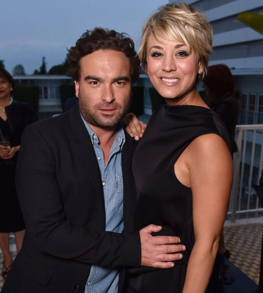 Kaley Cuoco 桌布 壁紙 — 一名男子和女子在晚間戶外活動中，在柔和環境燈光下緊密地擺姿勢。
