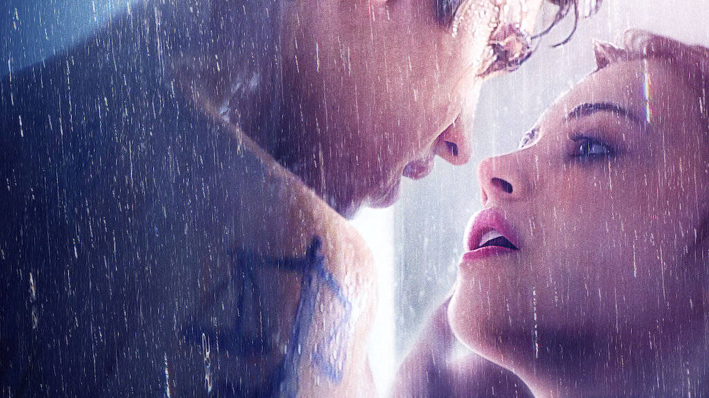 電影動圖 桌布 壁紙 — 一名男子和女子在暴雨中深情對望，雨水順著他們的臉龐和肩膀流下。