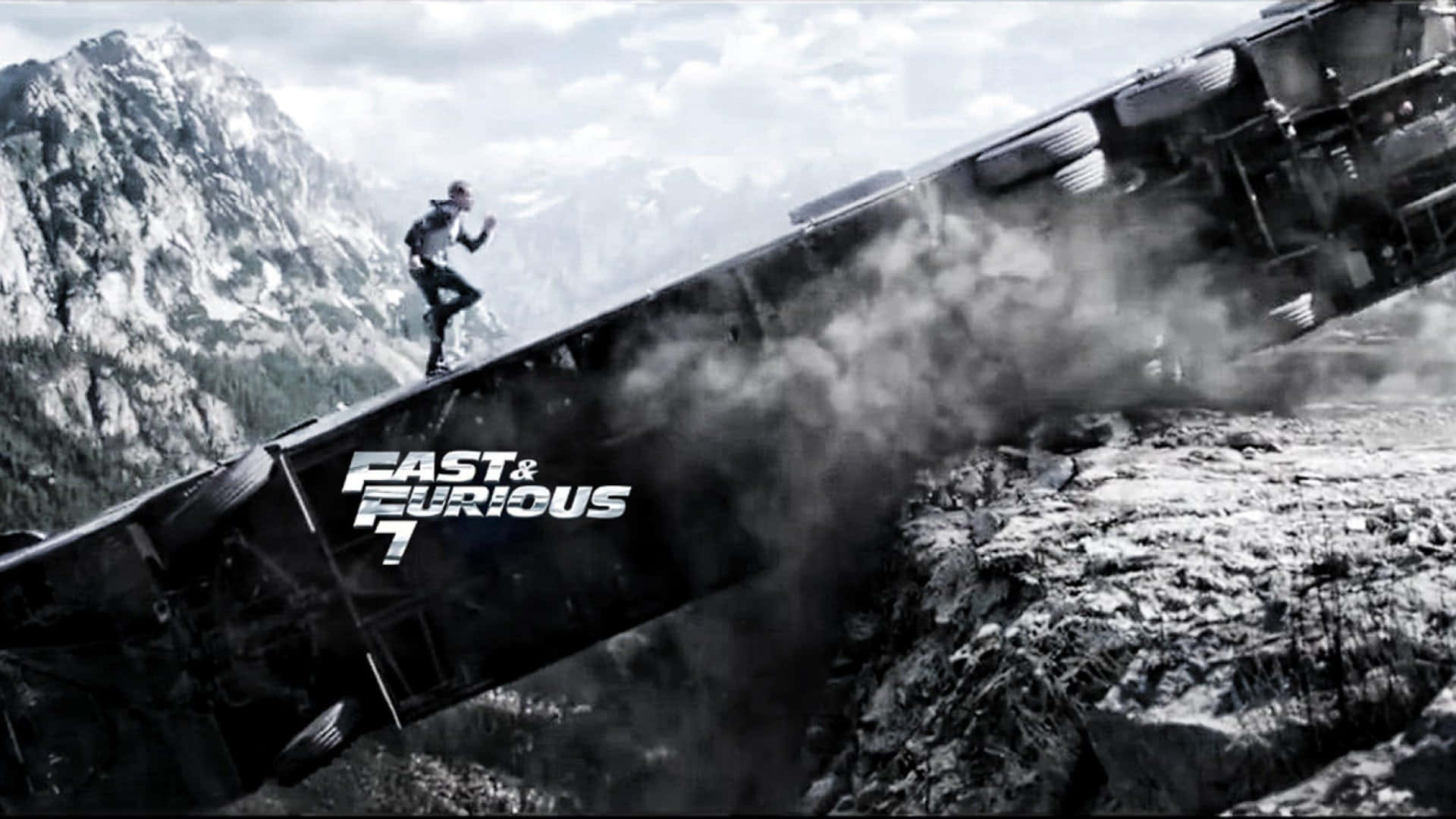 HD Fast And Furious 桌布 壁紙 — 一名男子在傾斜的火車車廂上奔跑，車廂懸掛在岩石懸崖上方，背景是白雪覆蓋的山脈。