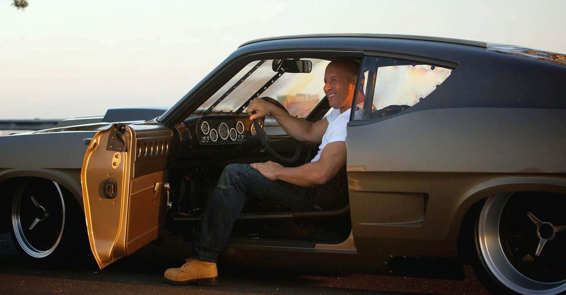 Ford Mustang 桌布 壁紙 — 一名男子在日落時分坐在一輛訂製的肌肉車內，車門敞開，咧嘴而笑。