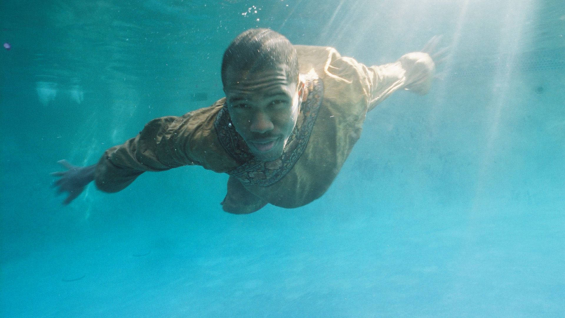 Frank Ocean 桌布 壁紙 — 一名男子在泳池中潛水，陽光透過清澈的藍色水照射下來。