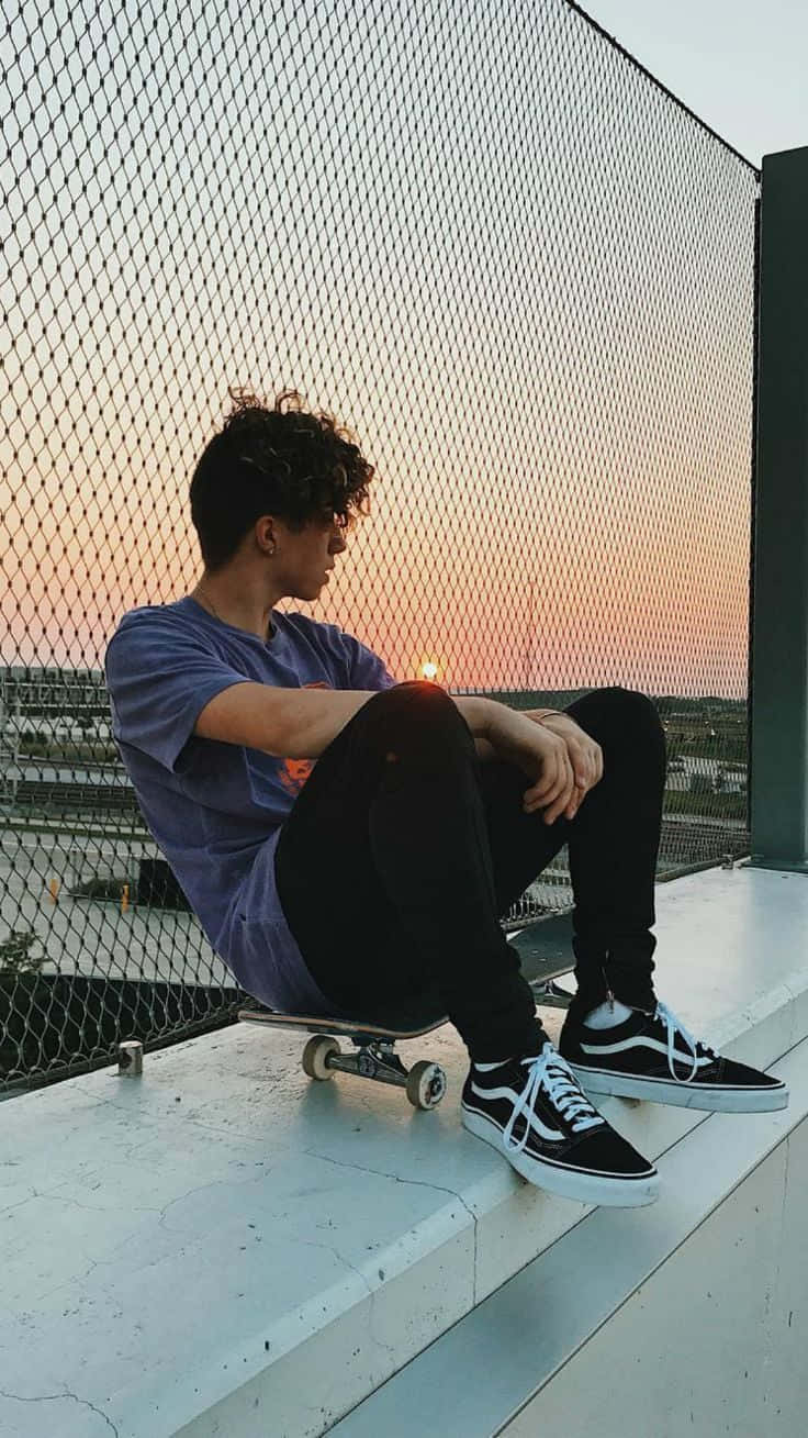 一名男子坐在滑板上 壁紙