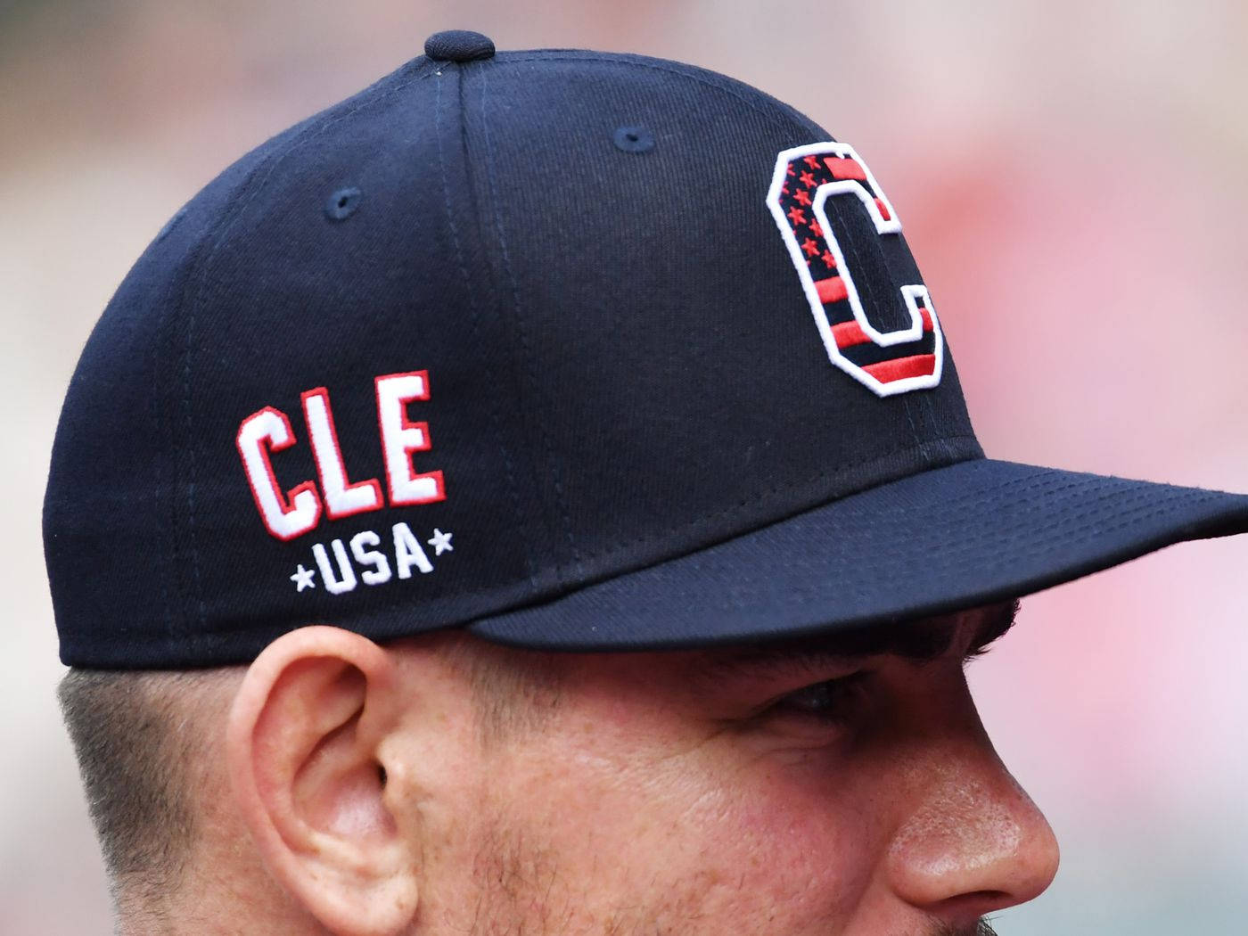 Cleveland Guardians 桌布 壁紙 — 一名男子戴著海軍藍色棒球帽，上面有紅、白、藍色的CLE USA標誌的特寫。