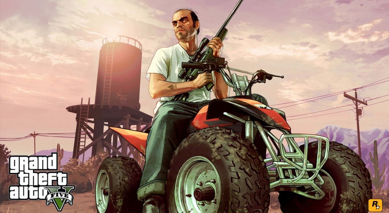 Gta 5 Desktop 桌布 壁紙 — 一名男子手持步槍，在日落時分坐在沙漠小鎮的橙色ATV上，背景有儲水塔和山脈。