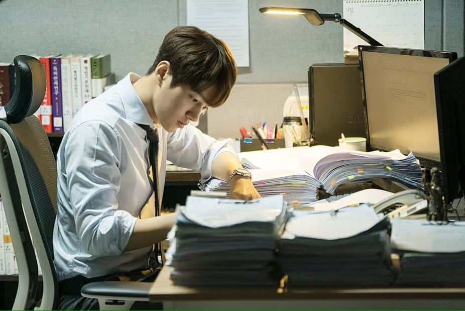 一名男子正在書桌前工作 壁紙