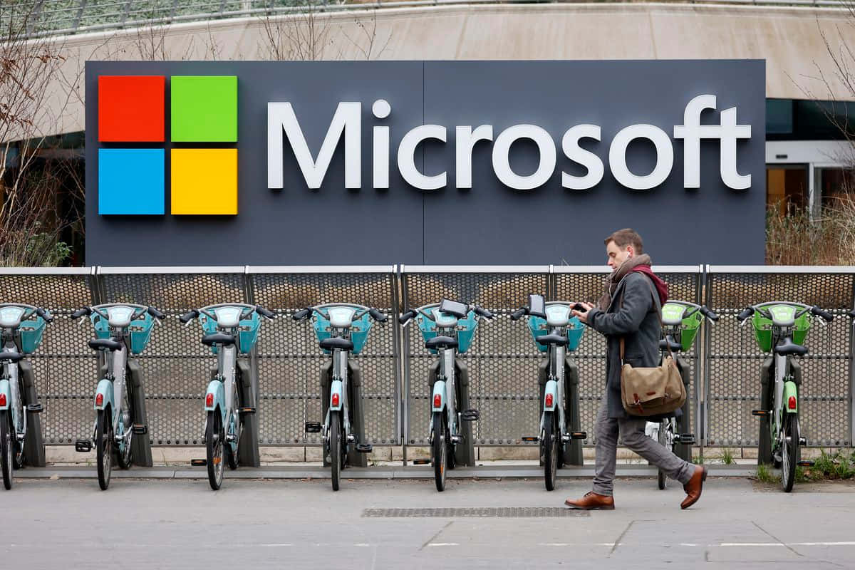 男子走過Microsoft標誌及停放的腳踏車 — Microsoft 壁紙