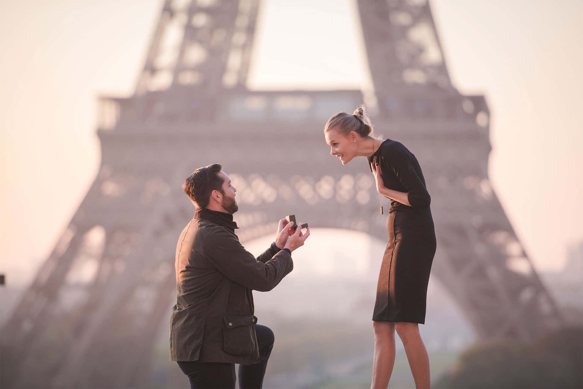 Proposal 桌布 壁紙 — 一名男子跪在微笑的女子面前，在黃金時刻的艾菲爾鐵塔前求婚。