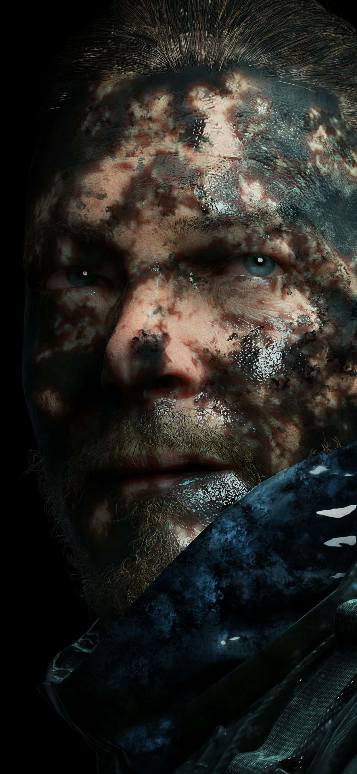 iPhone Xs Max Death Stranding 桌布 壁紙 — 一名男子飽經風霜的臉部特寫，臉上佈滿泥濘和污垢，一雙強烈的藍色眼睛在黑暗背景下顯得格外突出。