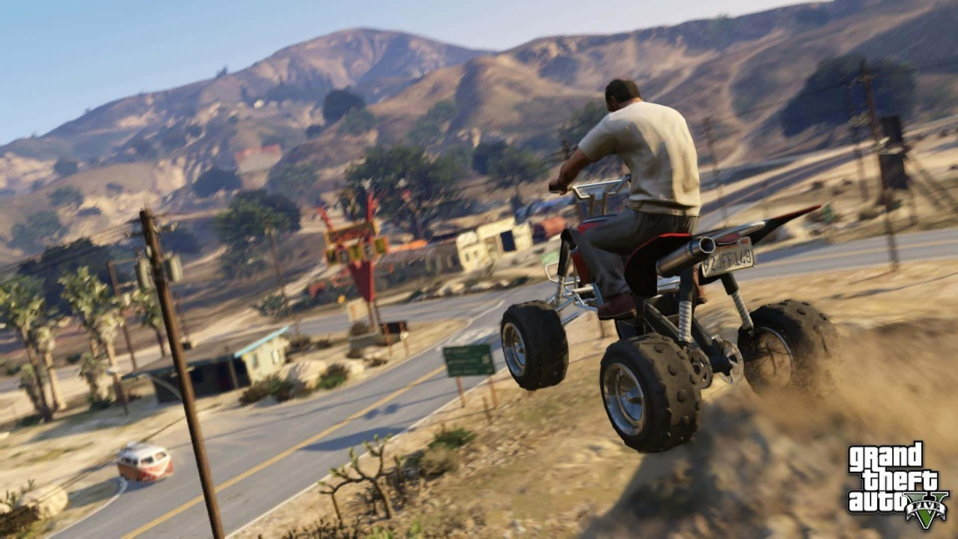 Gta 5 Desktop 桌布 壁紙 — 一名男子騎著紅色沙灘車在塵土飛揚的路邊騰空而起，背景是陽光明媚的沙漠景觀和山脈。