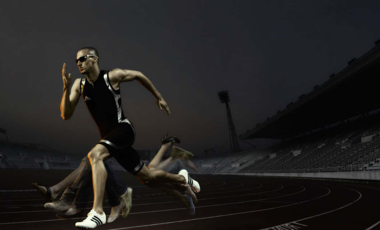Athletic 桌布 壁紙 — 一名男性短跑運動員穿著黑色裝備和太陽眼鏡，在黃昏時分的跑道上奔跑，背景是體育場座位。