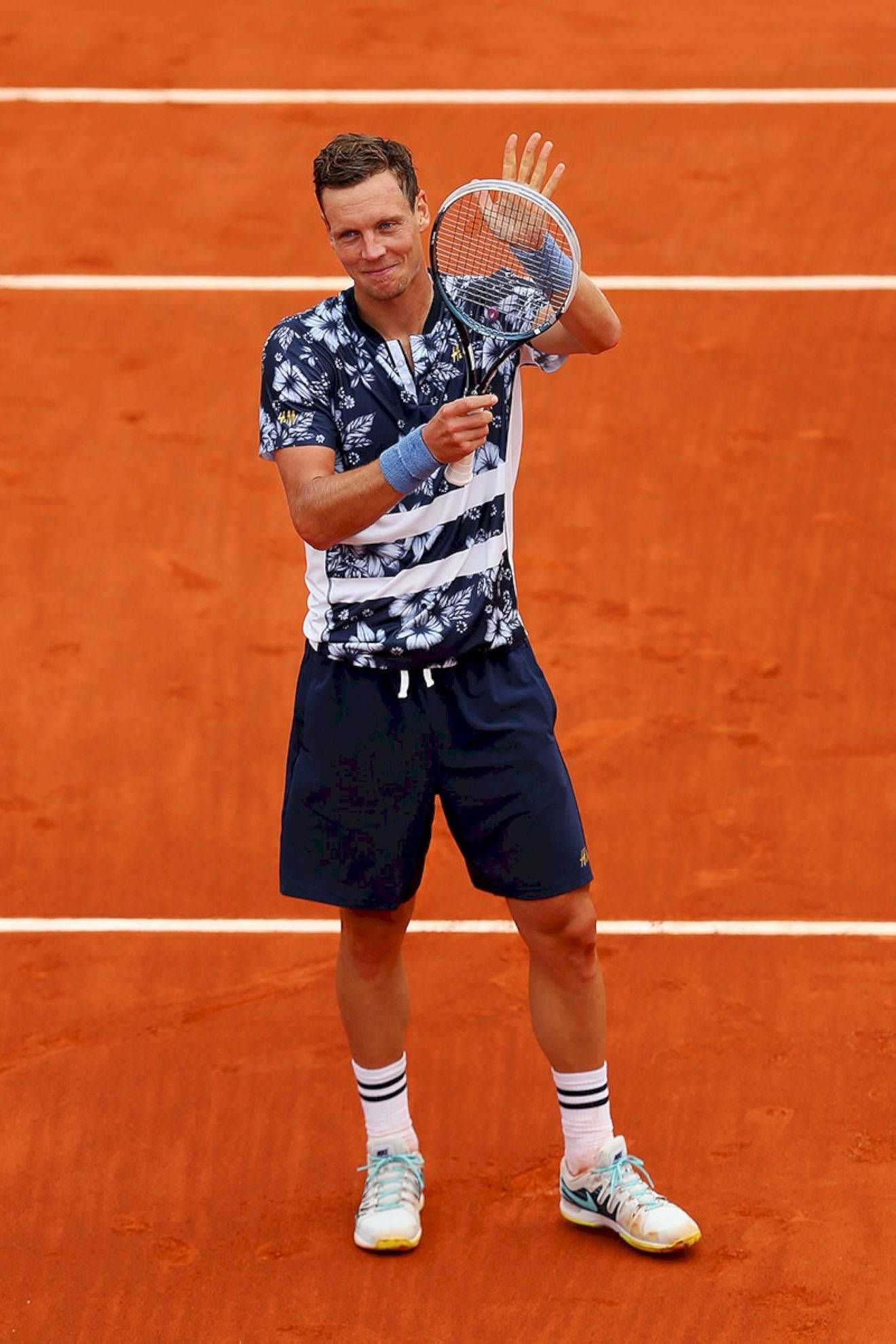 Tennis 桌布 壁紙 — 一名男性網球運動員在明亮的日光下，於充滿活力的橙色泥地球場上揮動球拍。