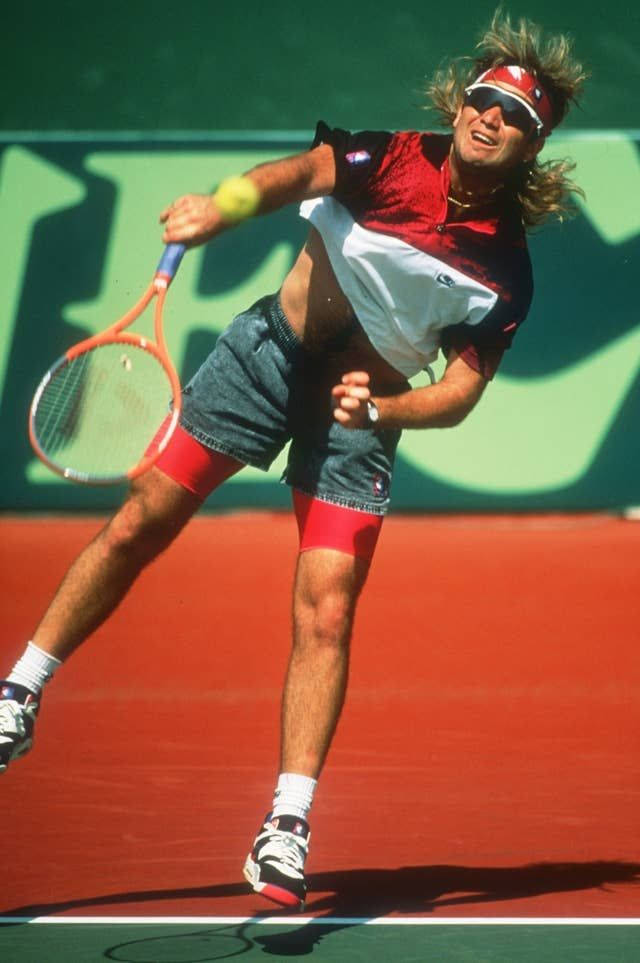 Tennis 桌布 壁紙 — 一名男性網球運動員在紅色球場上揮拍，背景為綠色，陽光普照。