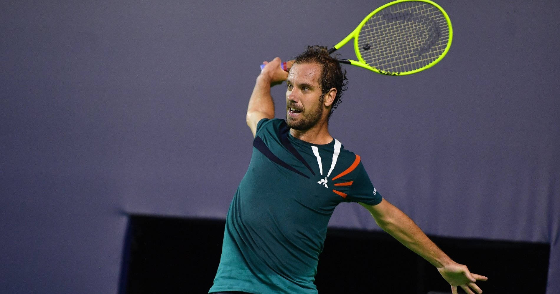 Tennis 桌布 壁紙 — 一名男性網球運動員正揮動螢光黃色球拍，背景為純紫色。