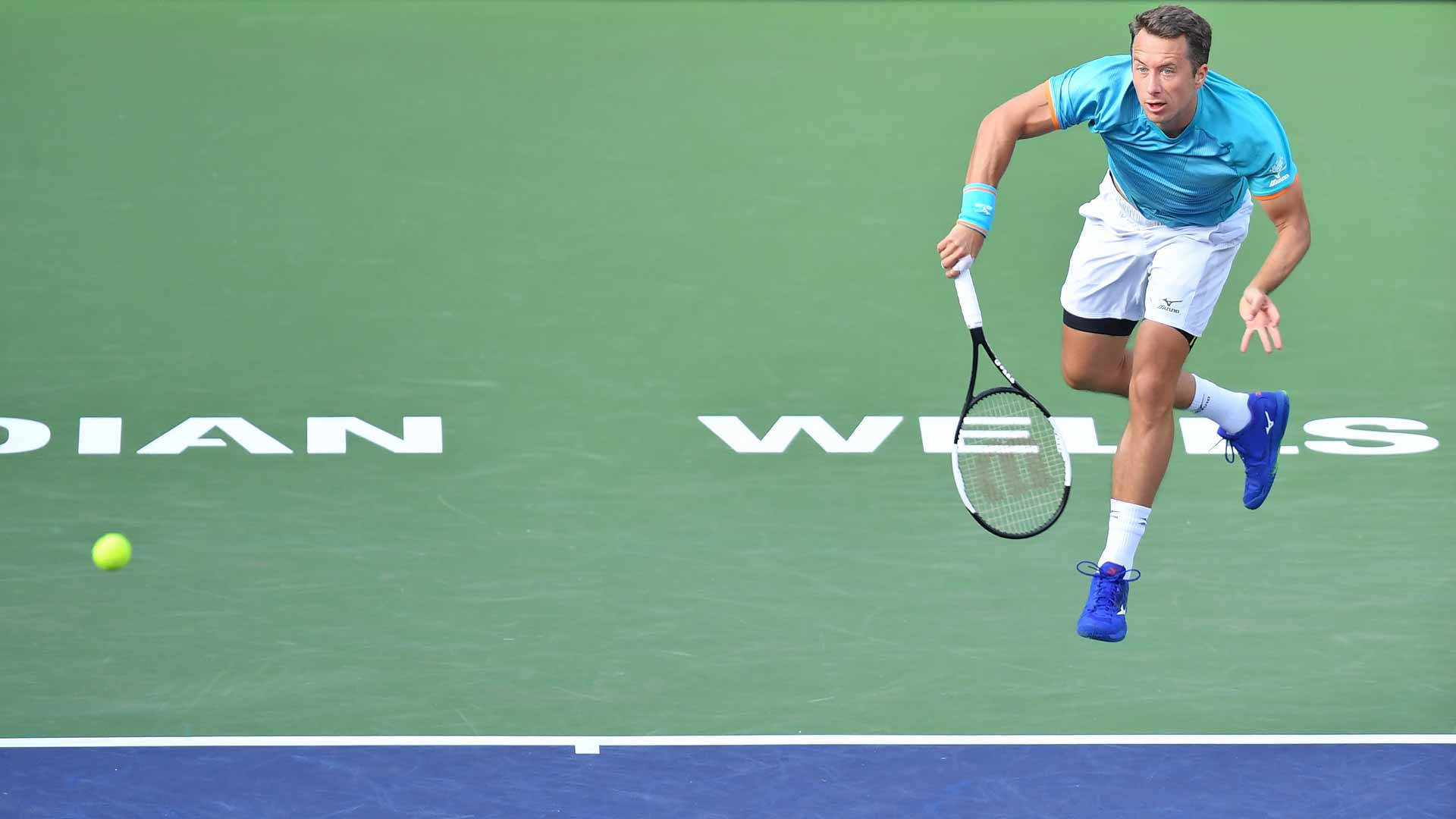 Athlete 桌布 壁紙 — 一名男性網球選手在綠色球場上躍起，以高度專注力扣殺黃色網球。