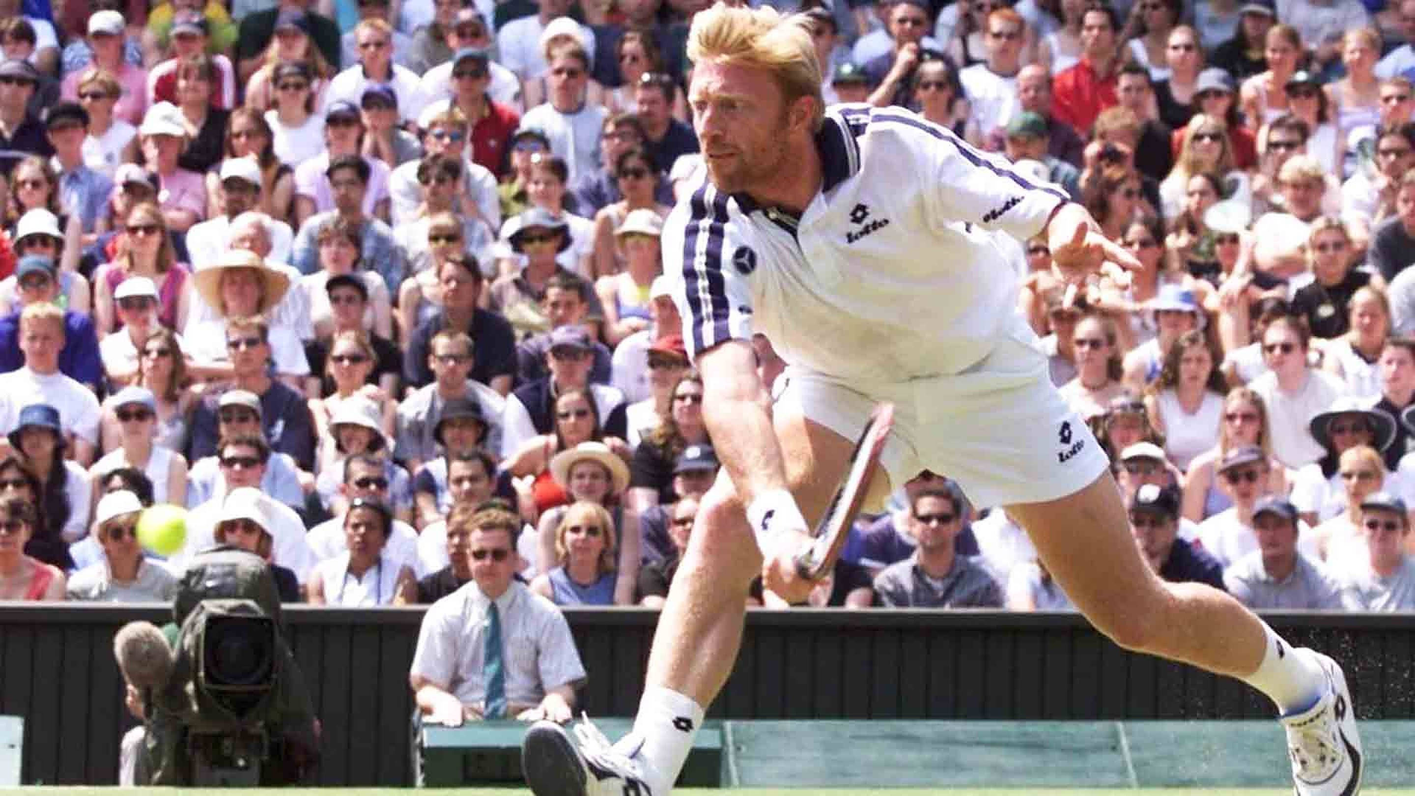 Boris Becker 桌布 壁紙 — 一名男性網球選手在草地上揮拍中途向前撲出，滿座觀眾在明亮的日光下觀看。