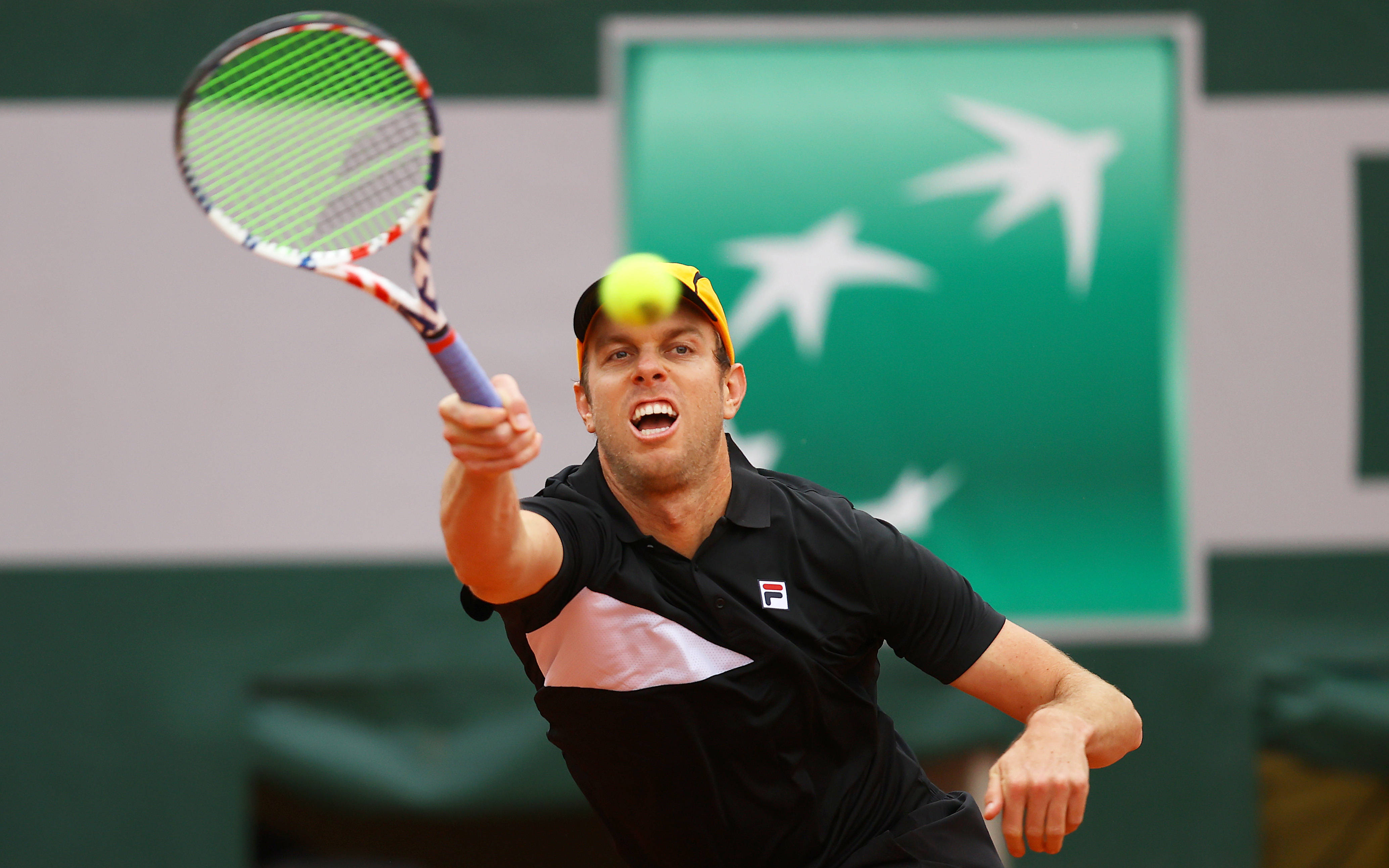 Tennis 桌布 壁紙 — 一名男網球選手在紅土球場上揮拍擊中黃色網球，神情專注。