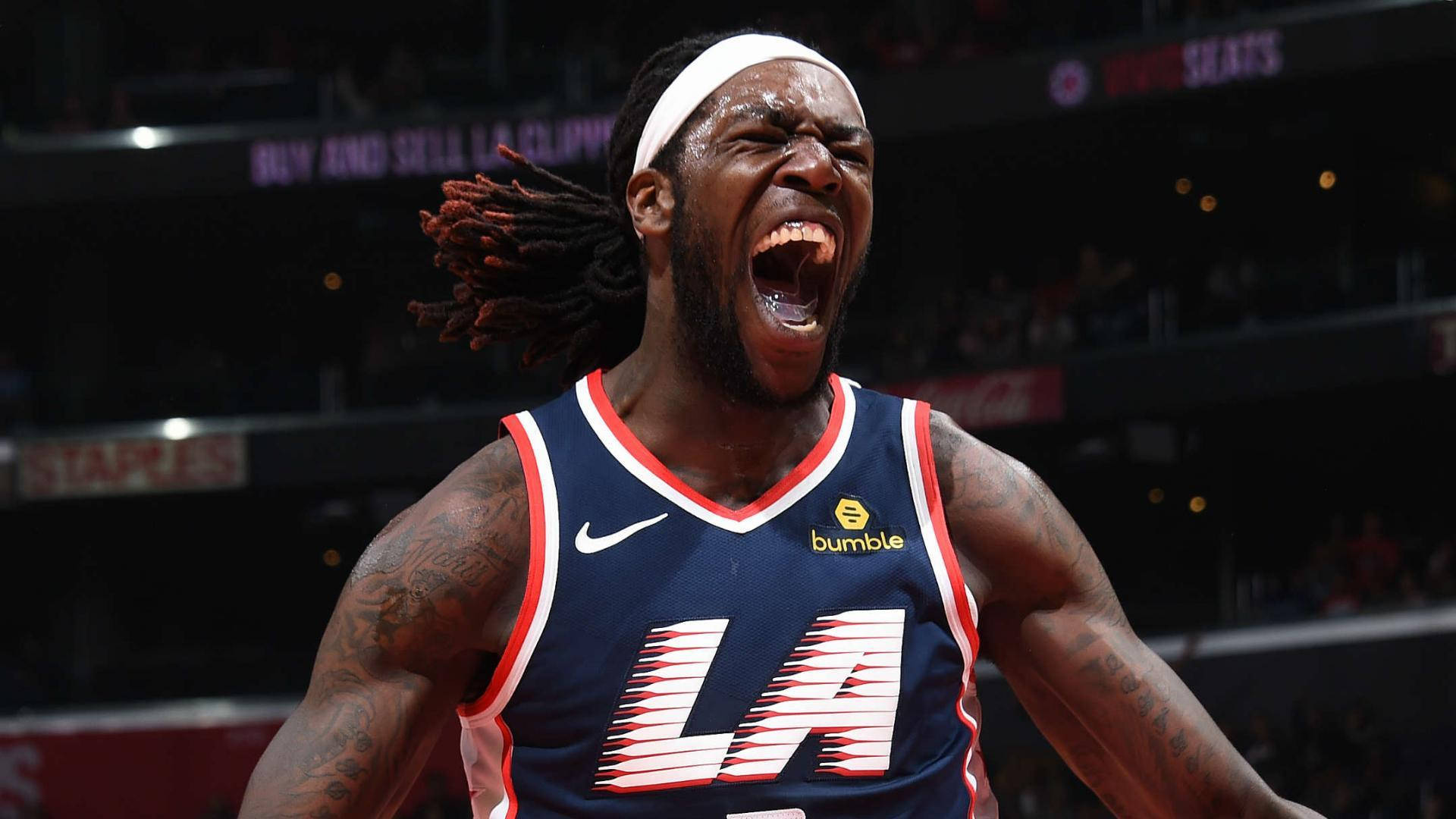 montrezl harrell 桌布 壁紙 — 一名留著辮子的籃球運動員在球場燈光下穿著LA快艇隊球衣勝利吶喊。