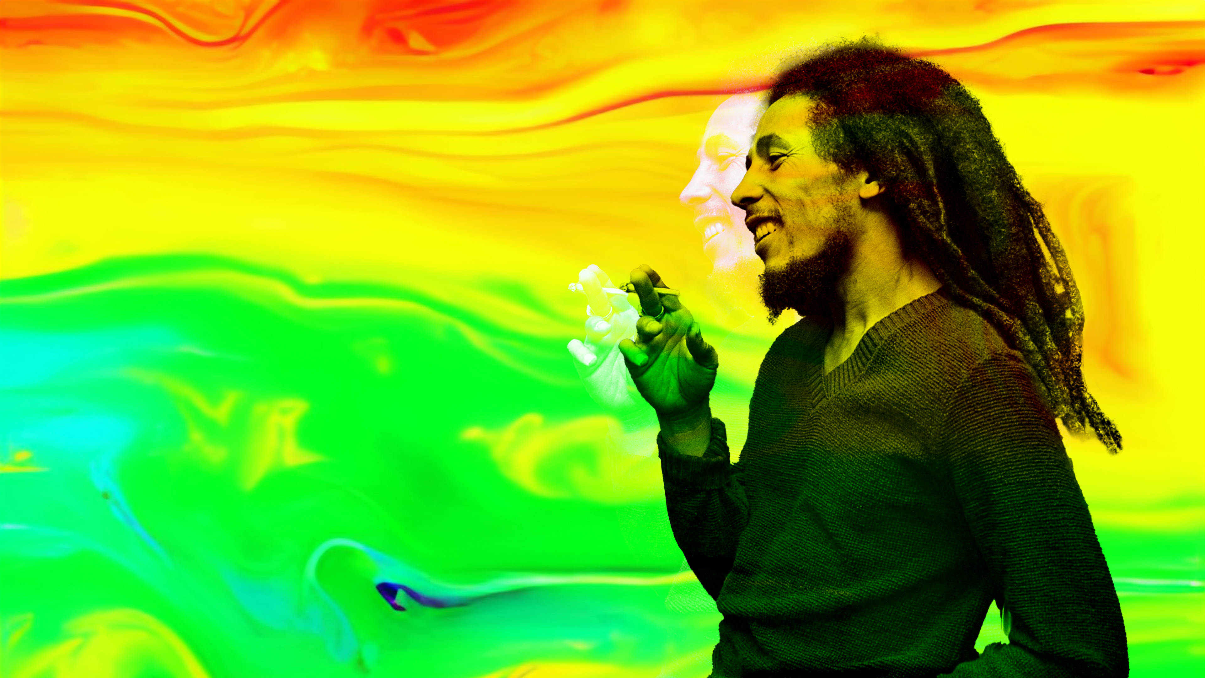 Bob Marley 桌布 壁紙 — 一名留著辮子頭的男人微笑著，手持一朵花，背景是黃、綠、橙色的鮮豔漩渦漸變色。