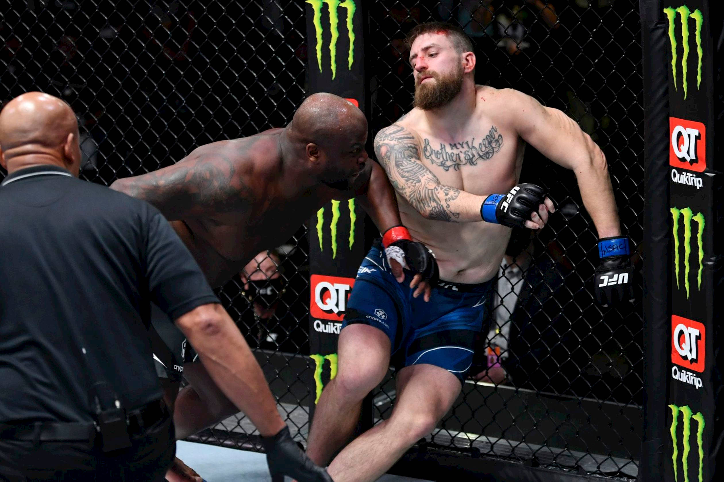 UFC 桌布 壁紙 — 一名留鬍子、有刺青的拳手靠在籠邊圍欄上，對手在綜合格鬥比賽中步步進逼。