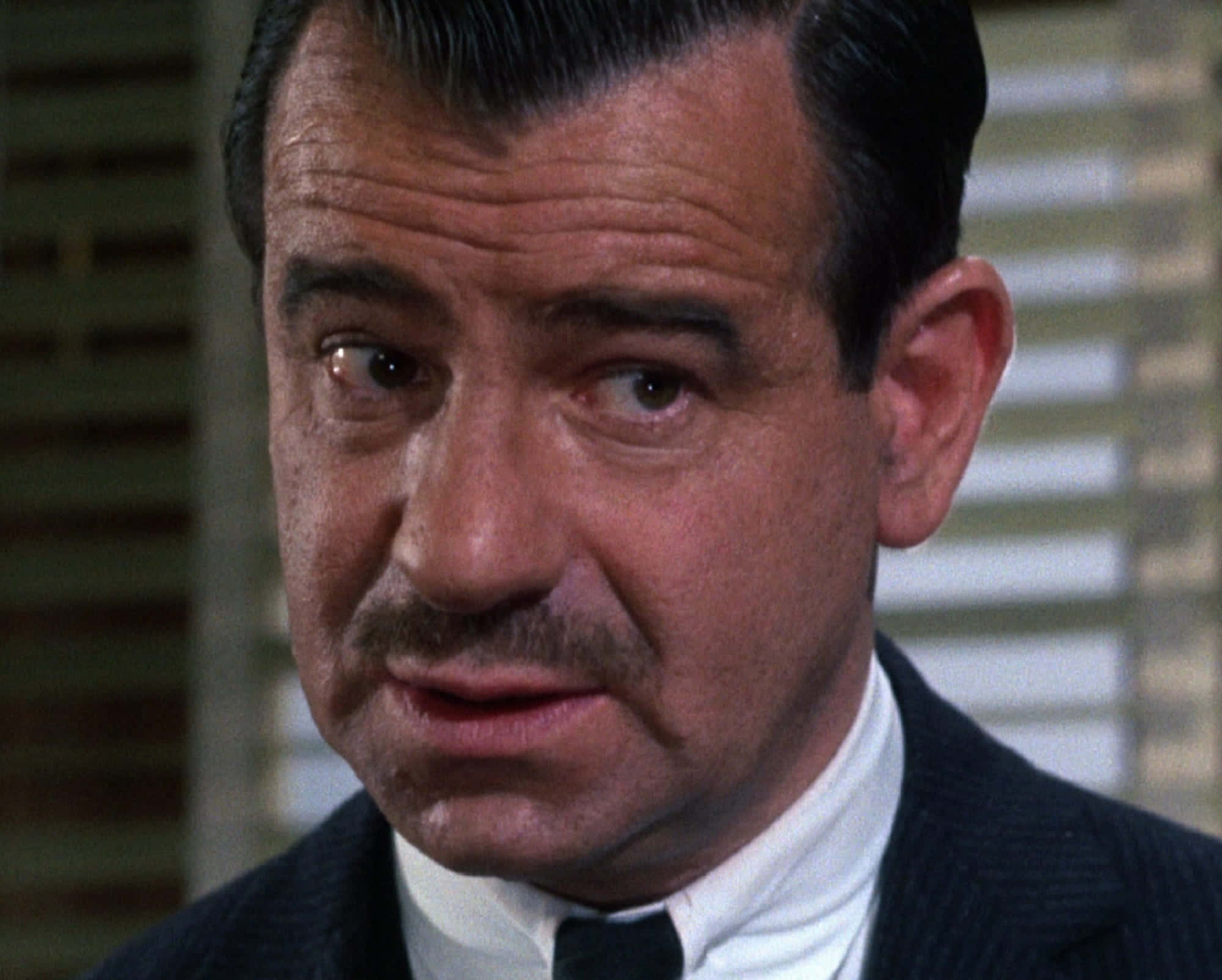 Walter Matthau 桌布 壁紙 — 一名留鬍鬚、身穿西裝的男子，表情嚴肅，專注地向前看的特寫。