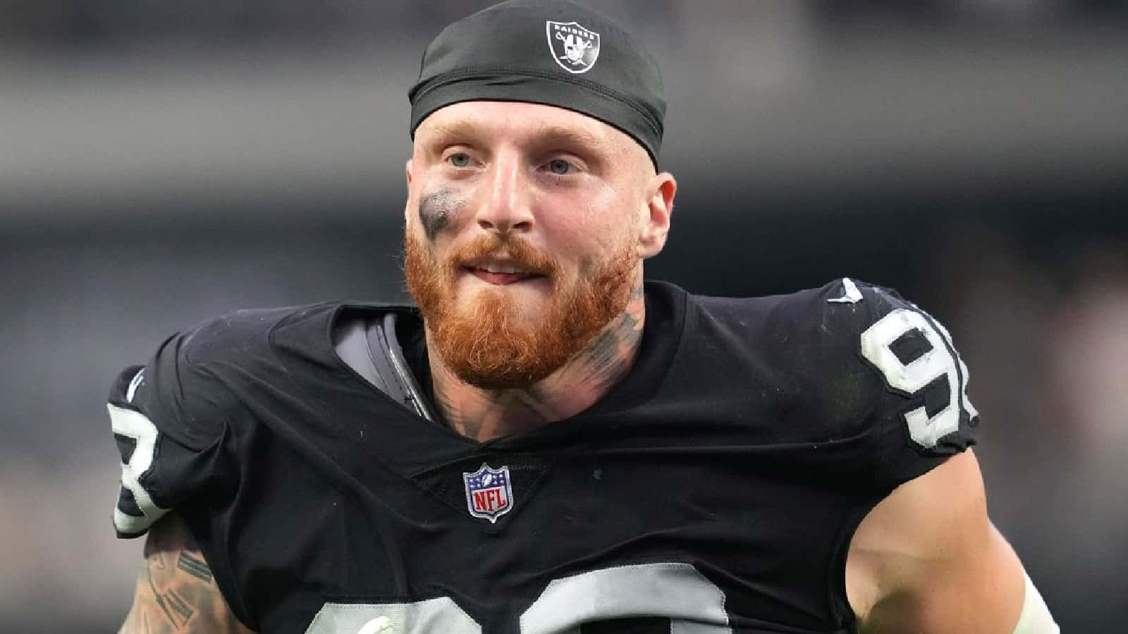 運動 桌布 壁紙 — 一名留鬍鬚的NFL美式足球員身穿黑色Raiders球衣，號碼92，在比賽中展現決心的特寫。