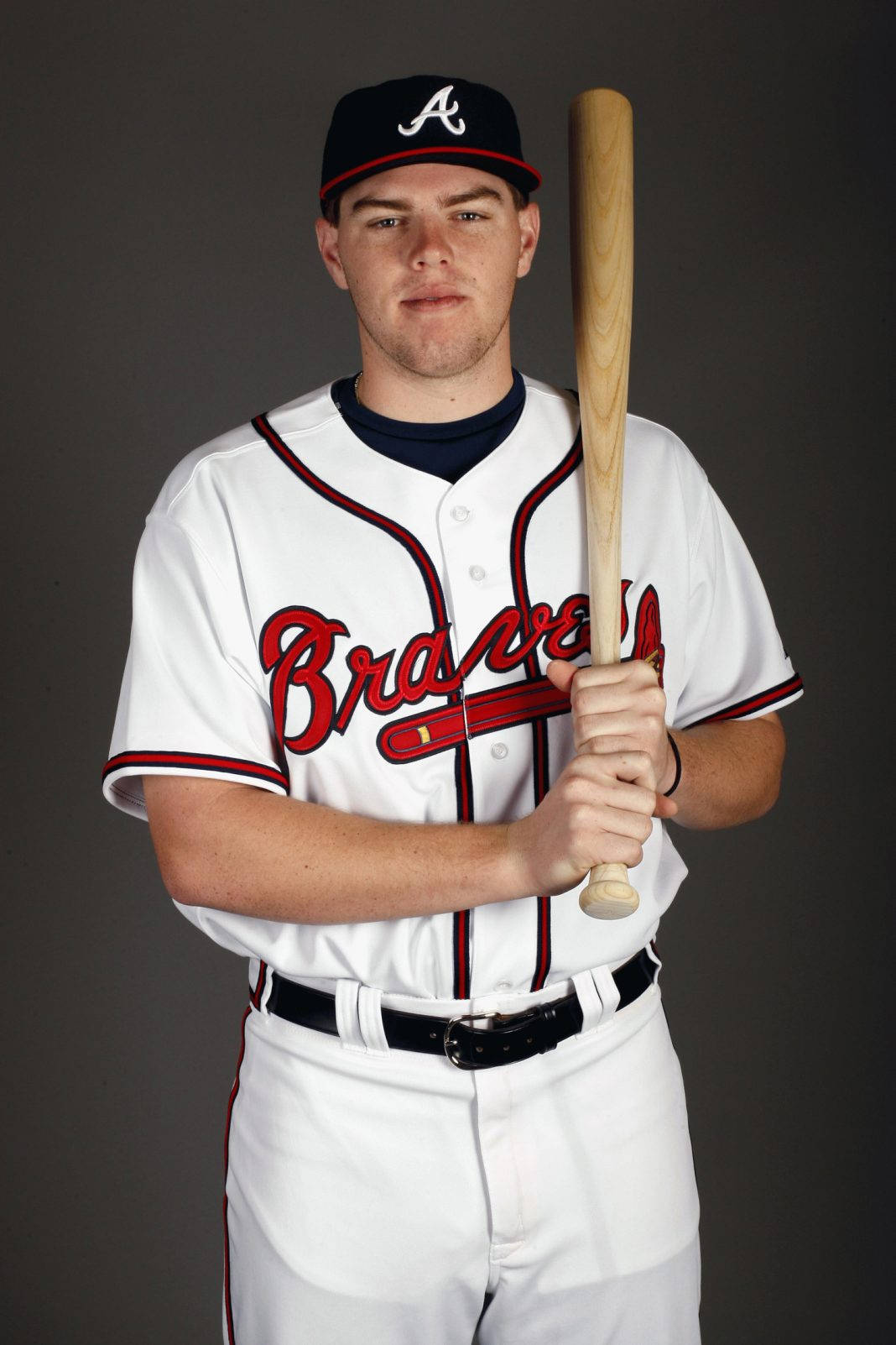 Freddie Freeman 桌布 壁紙 — 一名穿著勇士隊球衣的棒球選手，在純灰色攝影棚背景前手持木製球棒。
