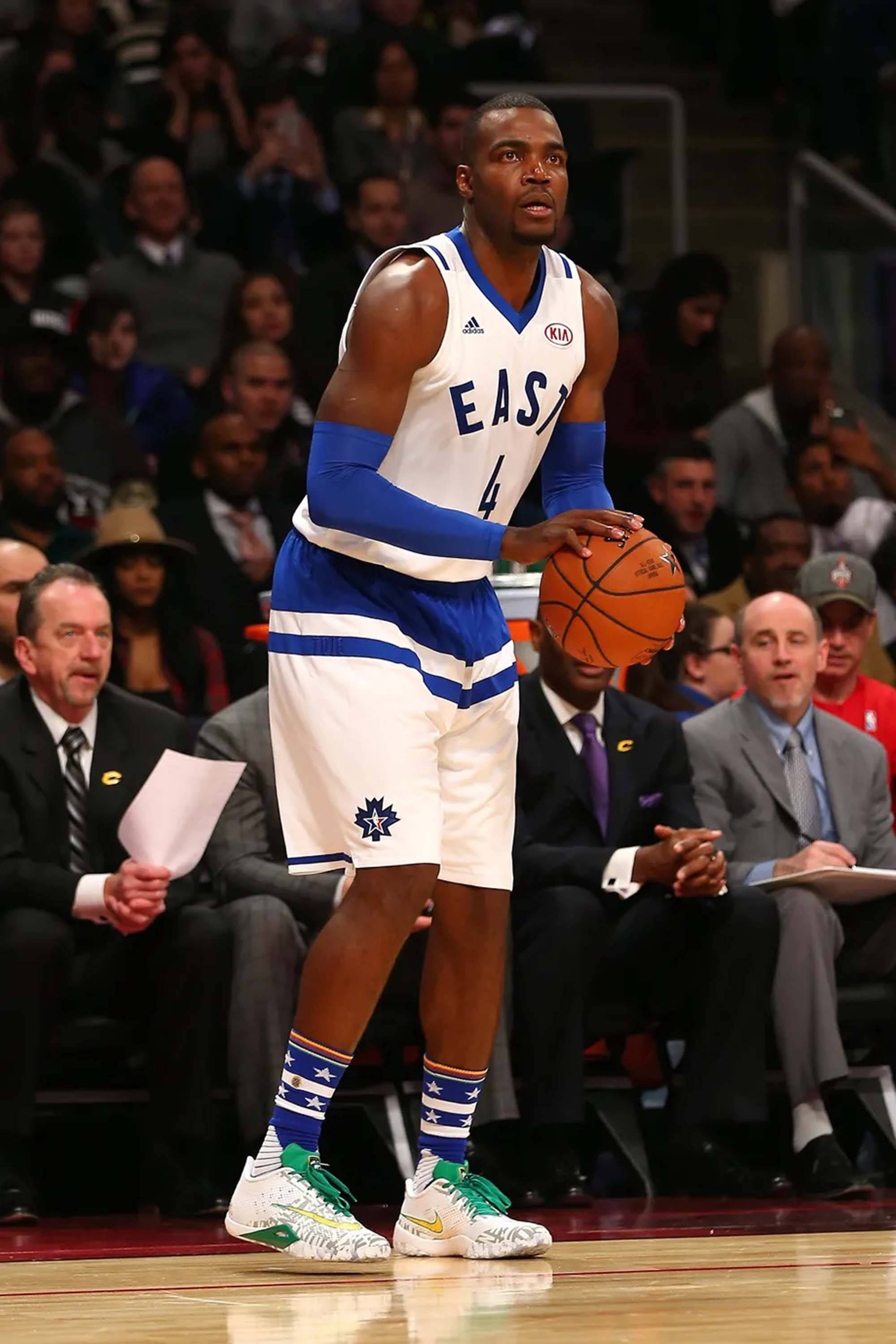 paul millsap 桌布 壁紙 — 一名穿著東部球衣的籃球運動員在比賽中專注地持球，在場館燈光下展現強烈專注力。